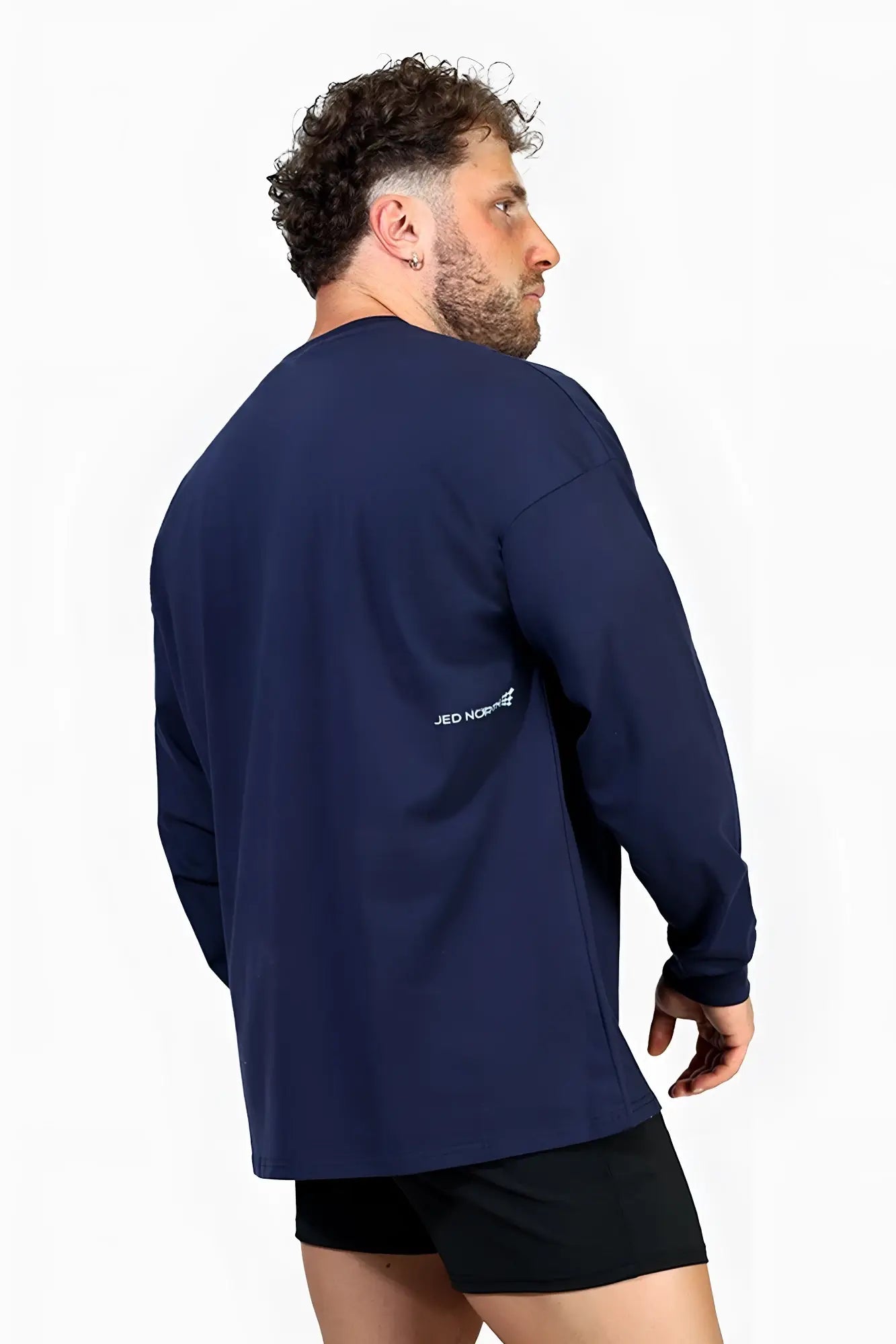 Back view of navy blue Jed North Energy oversized long sleeve t-shirt 2.0 with white Jed Norris text on upper back