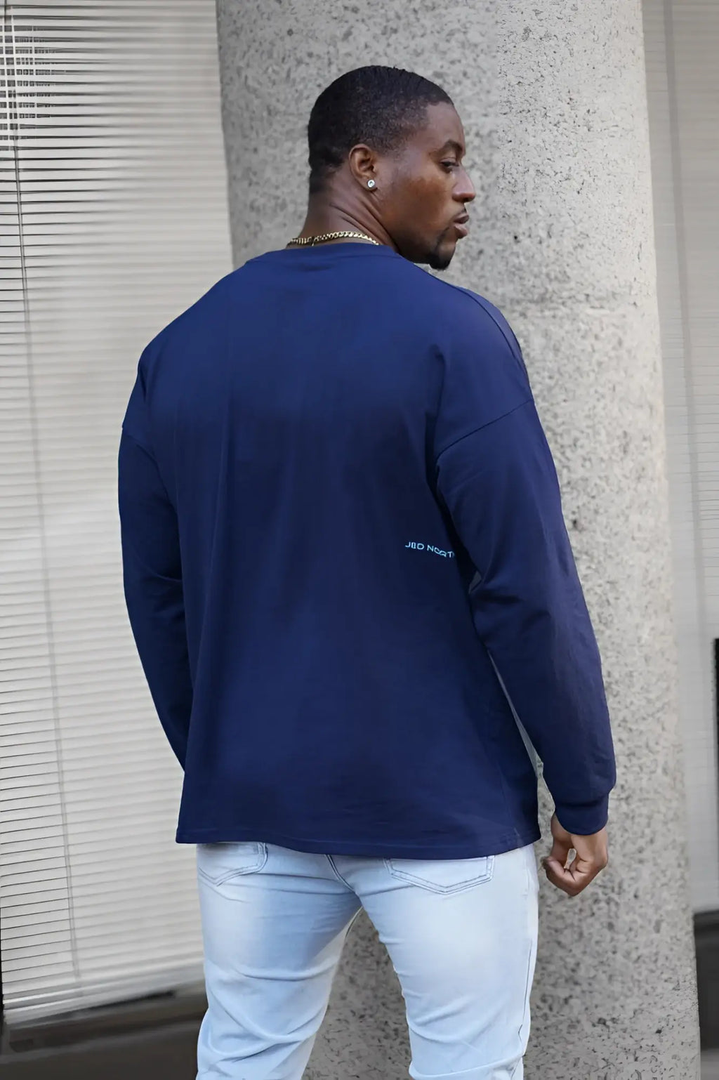 Navy blue long-sleeved jed north energy oversized t-shirt 2.0 with subtle light teal embroidery on the left sleeve