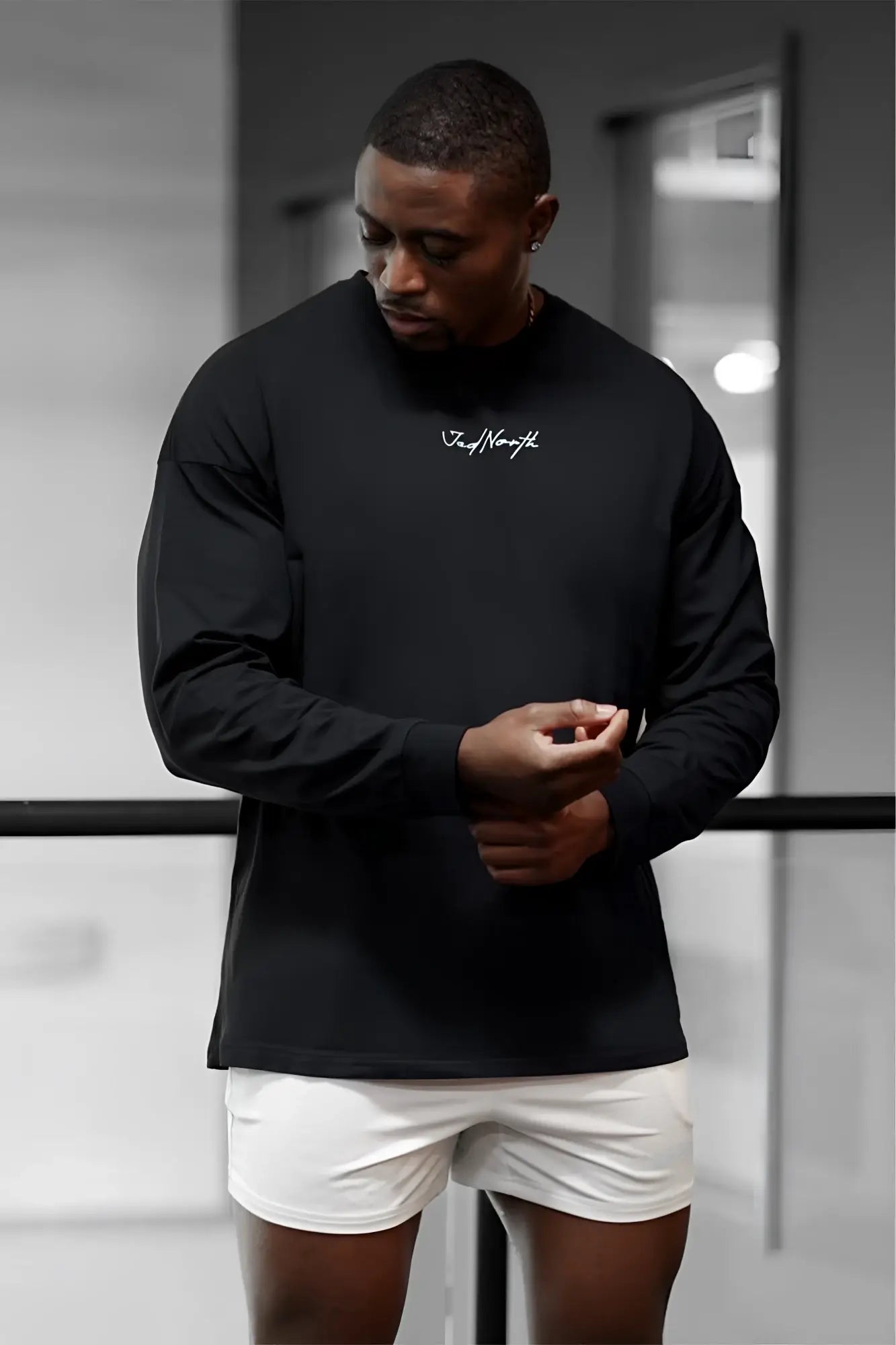 Black long-sleeve crewneck Jed North Energy oversized t-shirt with white cursive logo on the chest in obsidian black