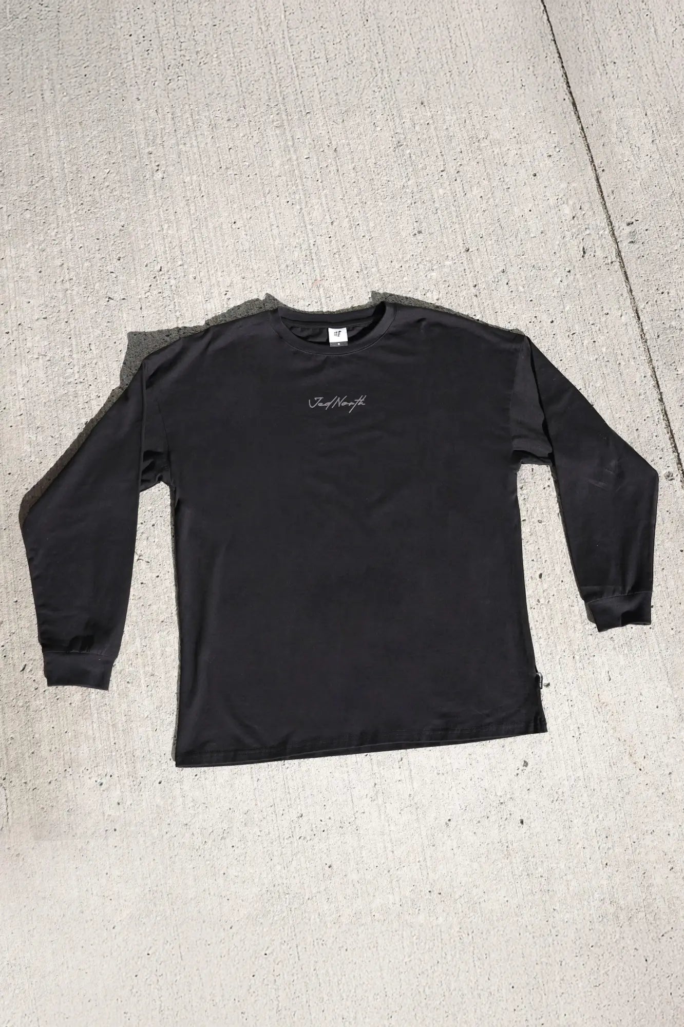 Black Jed North Energy oversized long sleeve t-shirt with subtle white cursive logo on the chest in obsidian black