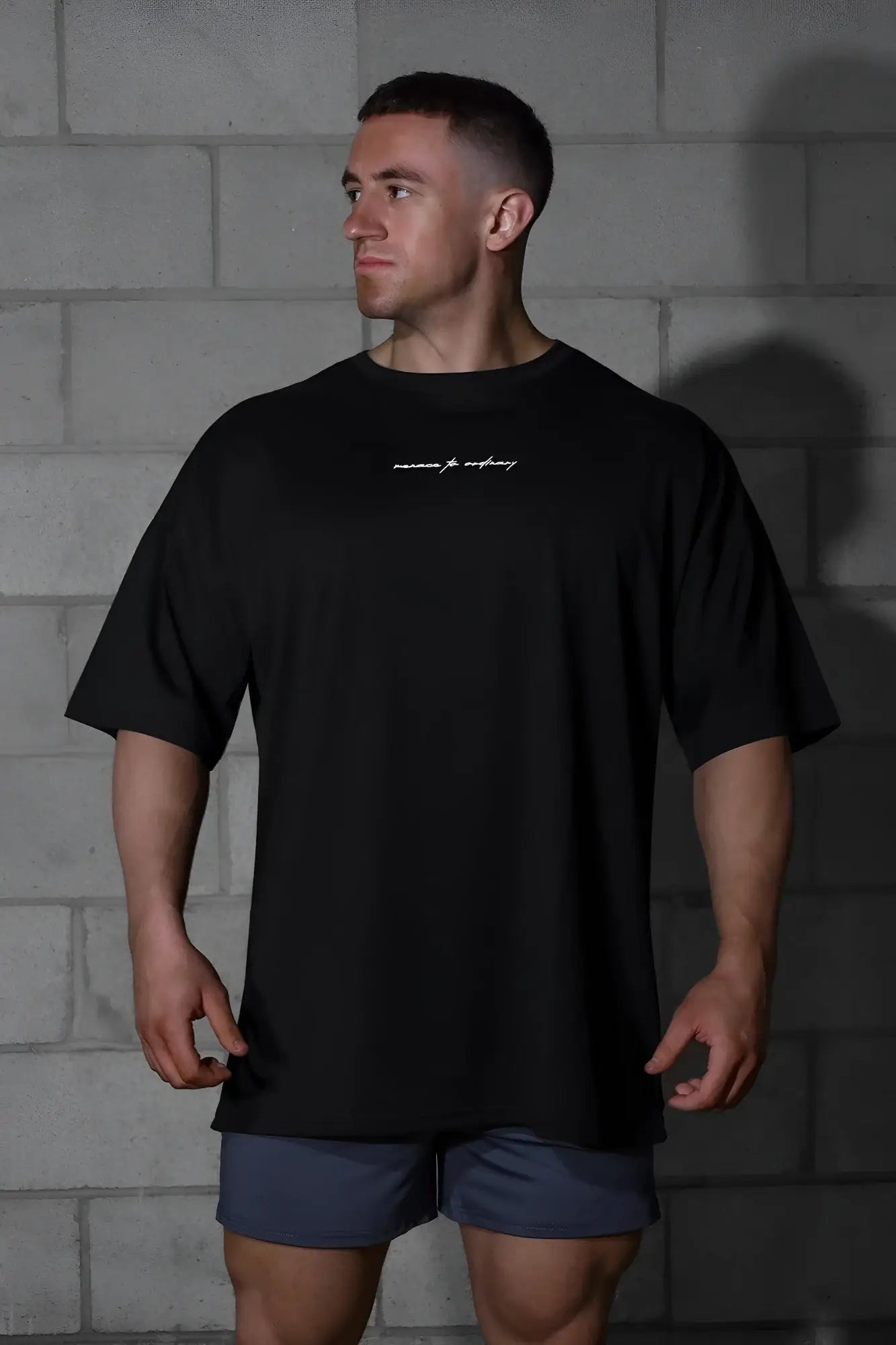 Black oversized jed north energy t-shirt with subtle white cursive logo across the chest in menace black color