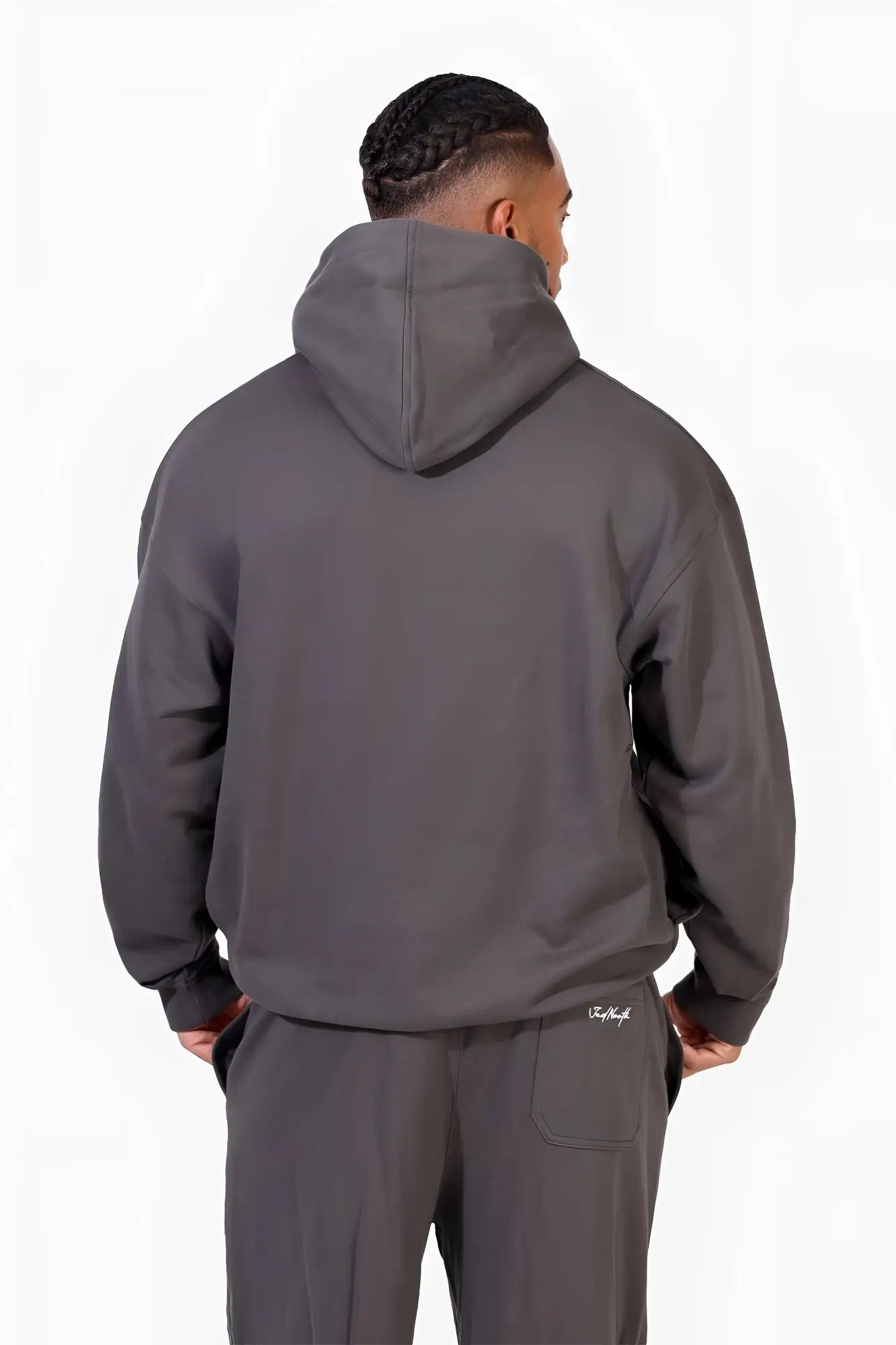 Back view of jed north essentials relaxed hoodie in dark gray with a subtle brand logo on the lower back