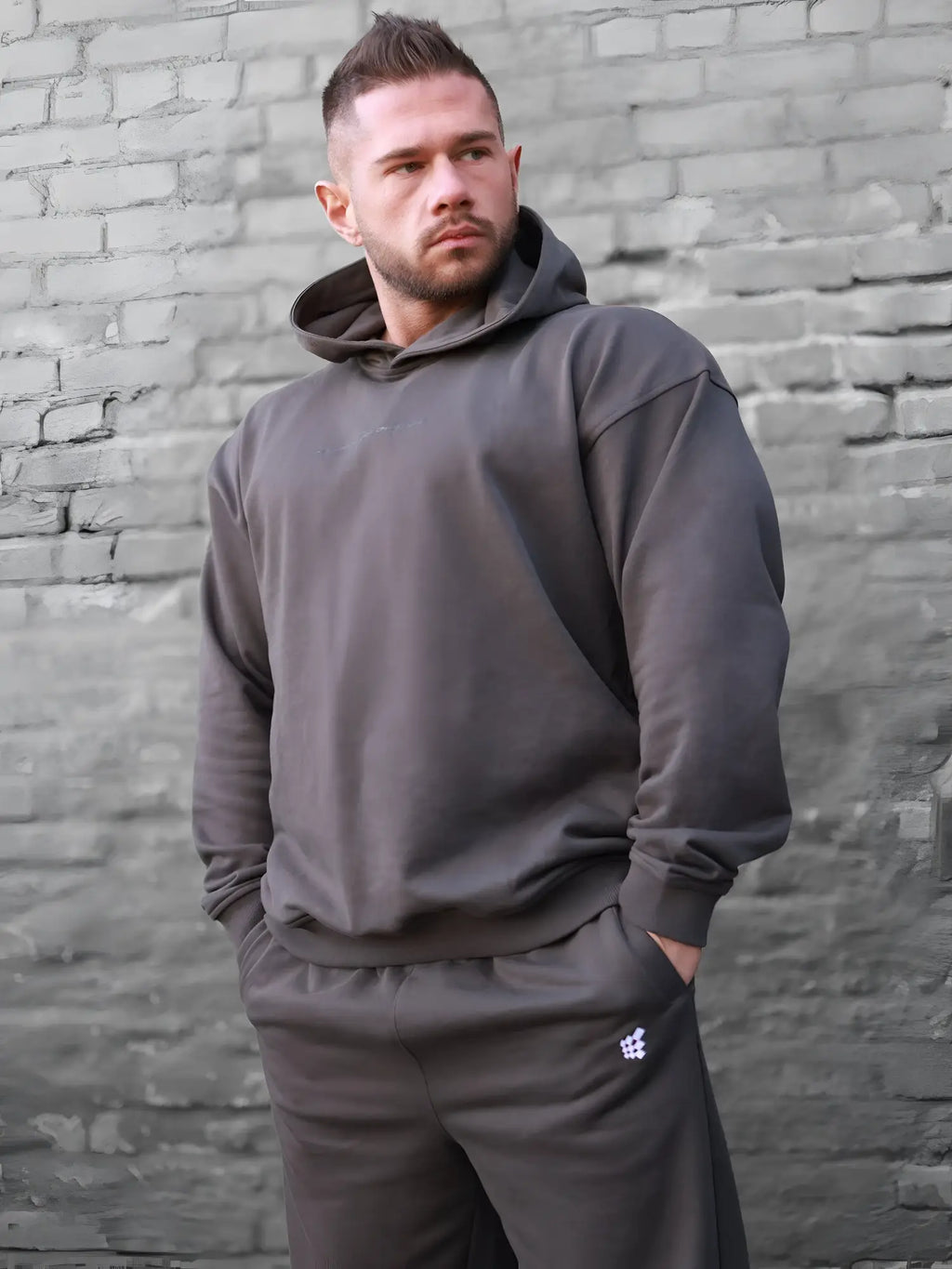 Dark gray jed north essentials relaxed hoodie with matching pants featuring a subtle logo on the left thigh