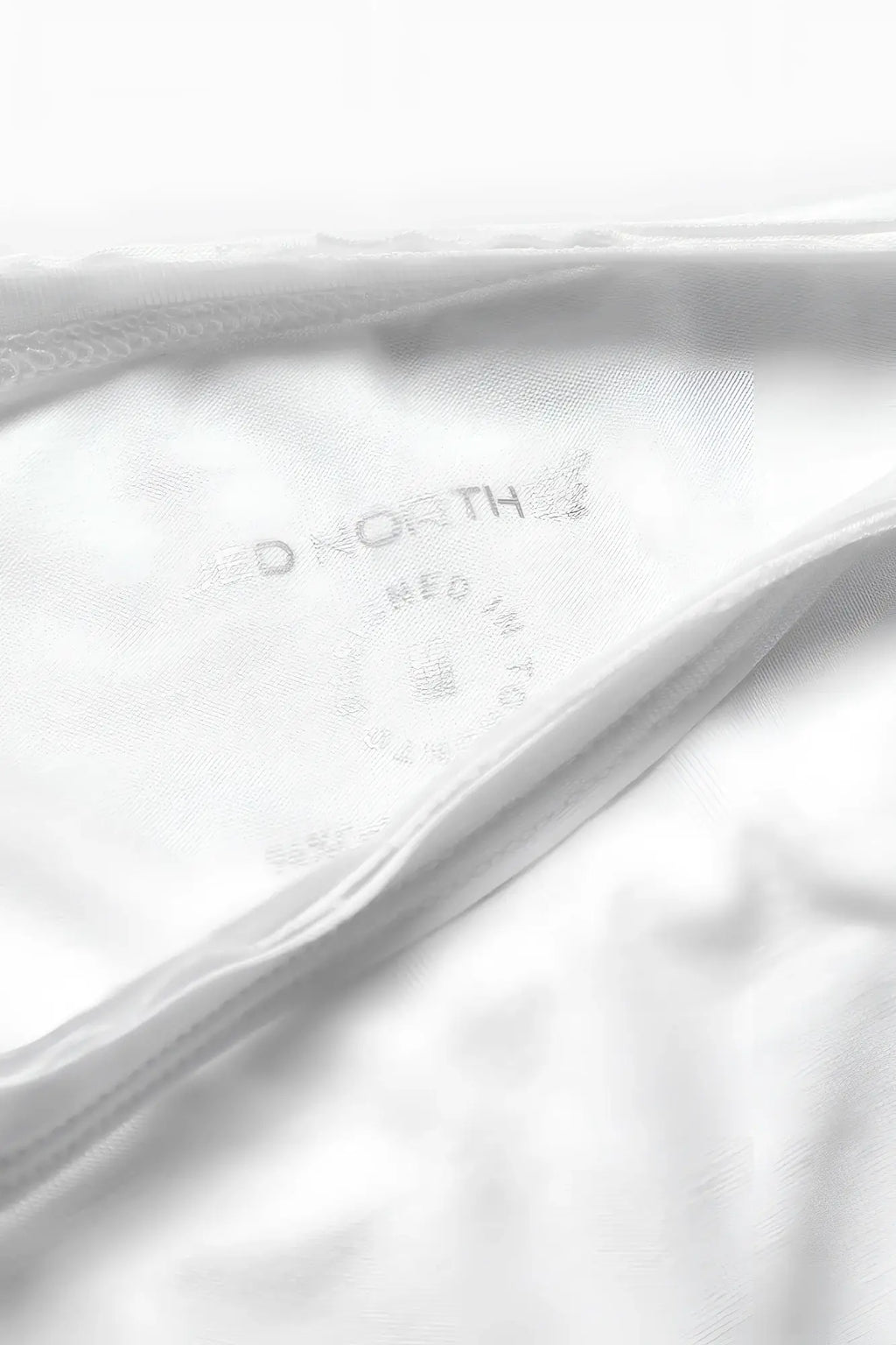 White cotton garment tag with aeropostale embossed branding on the jed north evolve cap sleeve muscle t shirt 2.0 off white