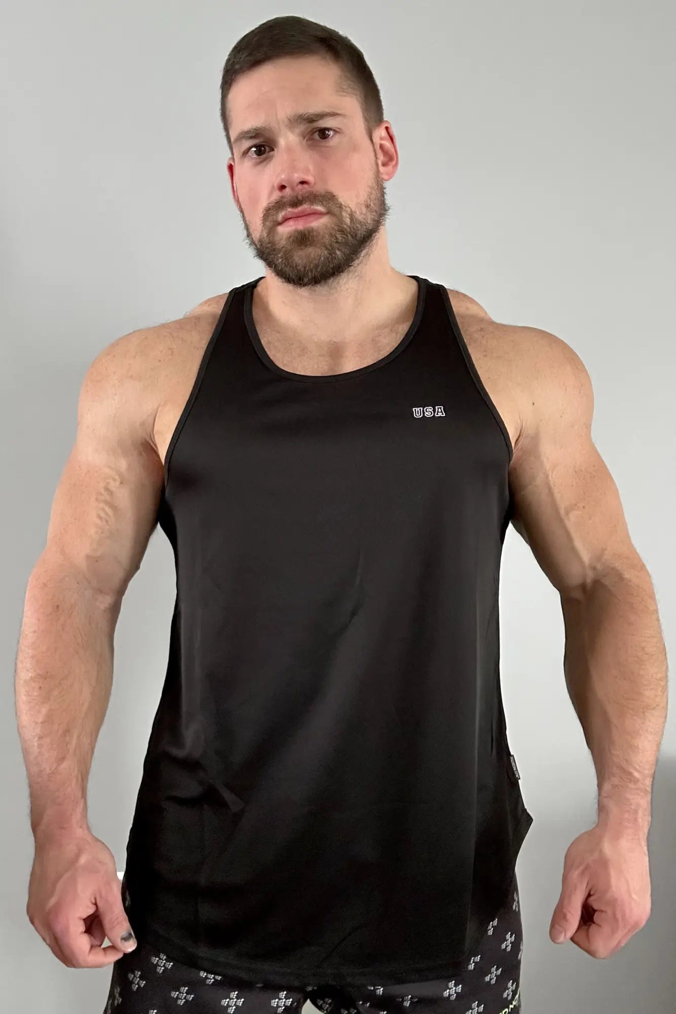 Black sleeveless fast-dry bodybuilding workout stringer with subtle white usa logo on upper left chest