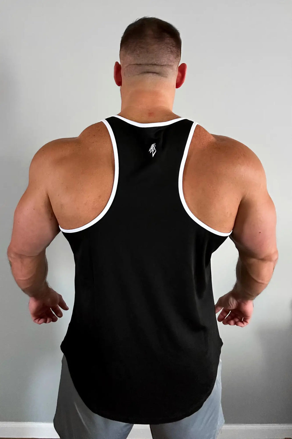 Black fast-dry bodybuilding workout stringer tank top with white trim around neckline and armholes