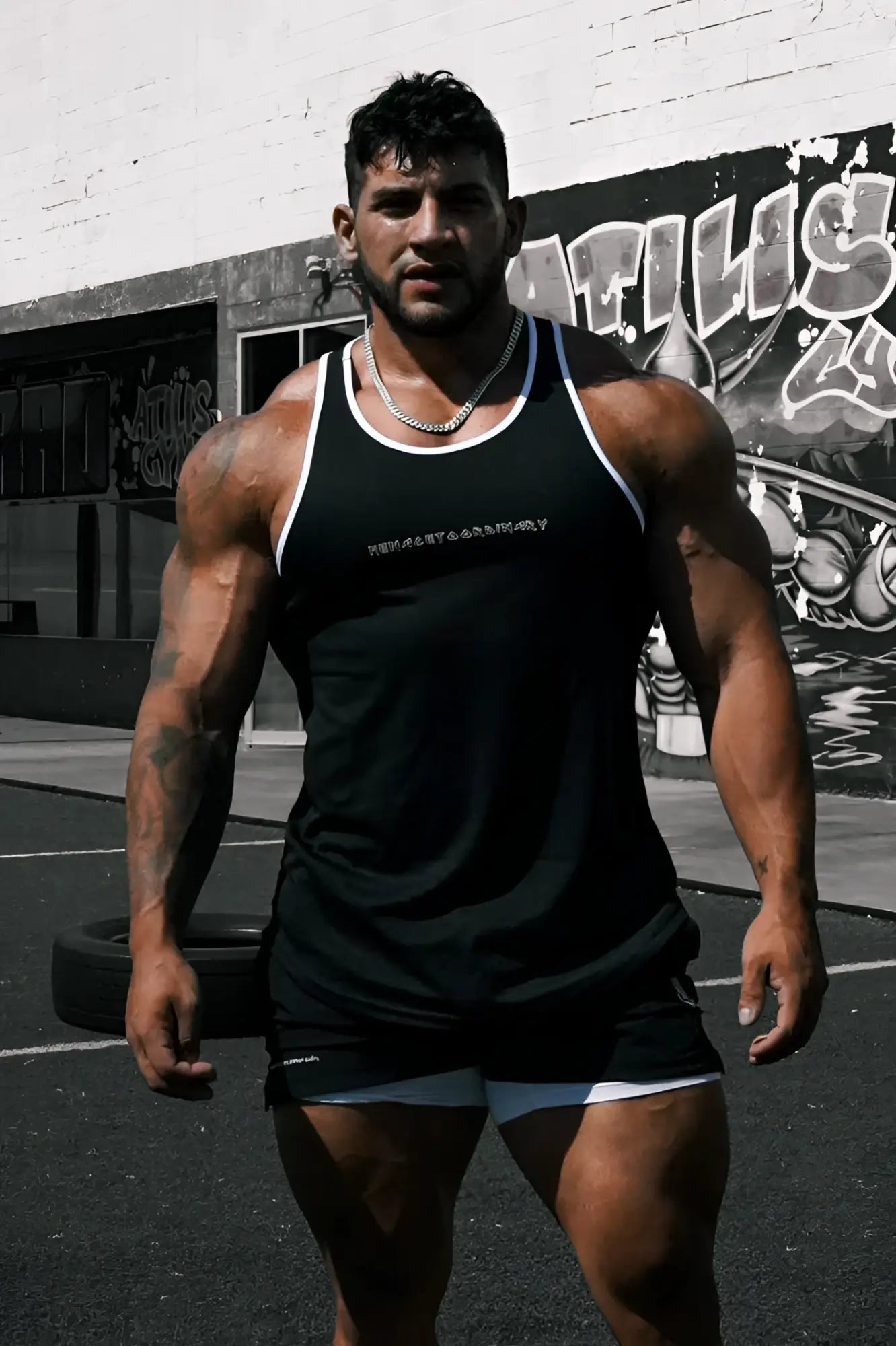 Black fast-dry bodybuilding workout stringer with white trim and subtle embroidered logo on the chest