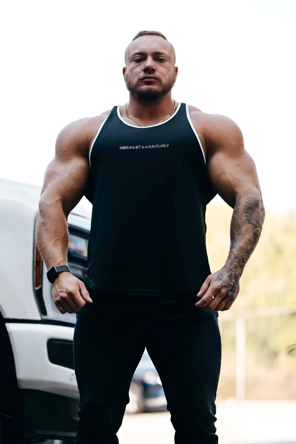 Black fast-dry bodybuilding workout stringer tank top with white trim and subtle logo across the chest