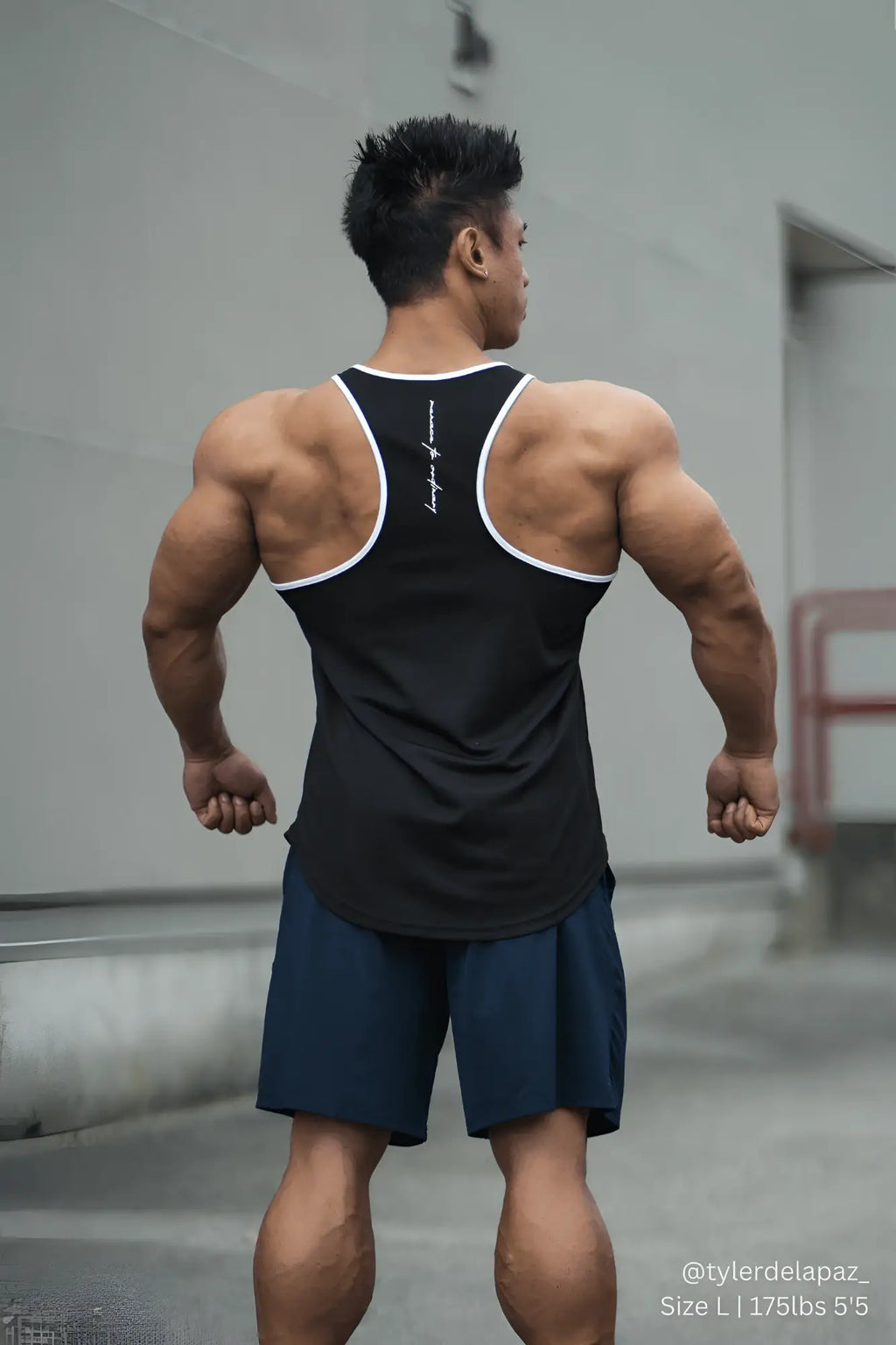 Back view of jed north fast-dry bodybuilding workout stringer tank top in black with white trim and vertical logo