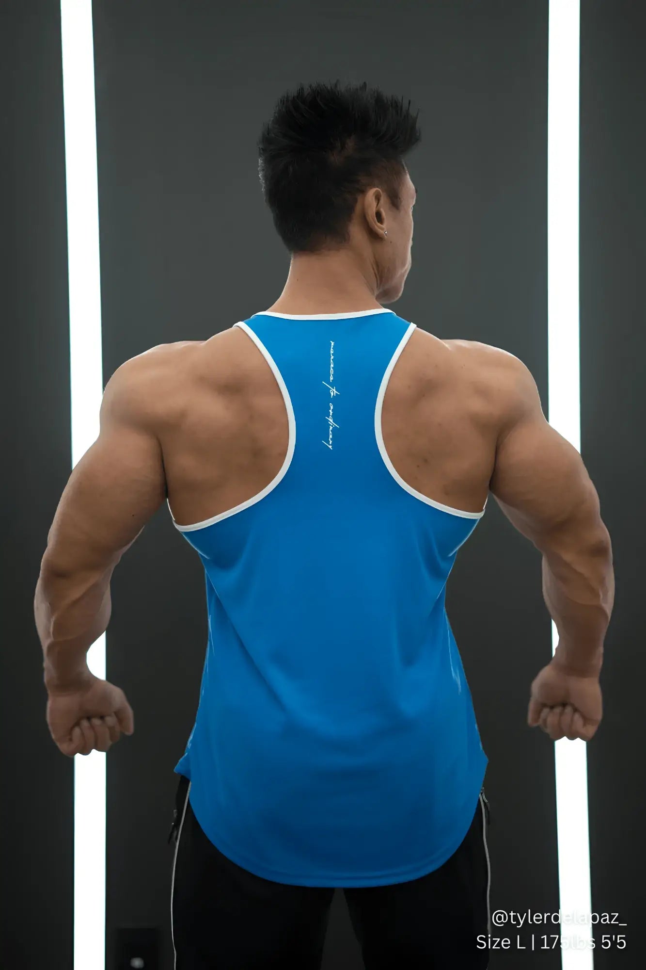 Back view of jed north fast-dry bodybuilding workout stringer tank top in blue with white trim and vertical script logo