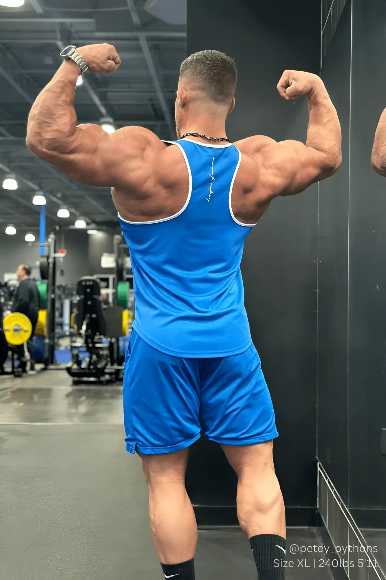Back view of jed north fast-dry bodybuilding workout stringer tank top in blue with white trim and vertical logo