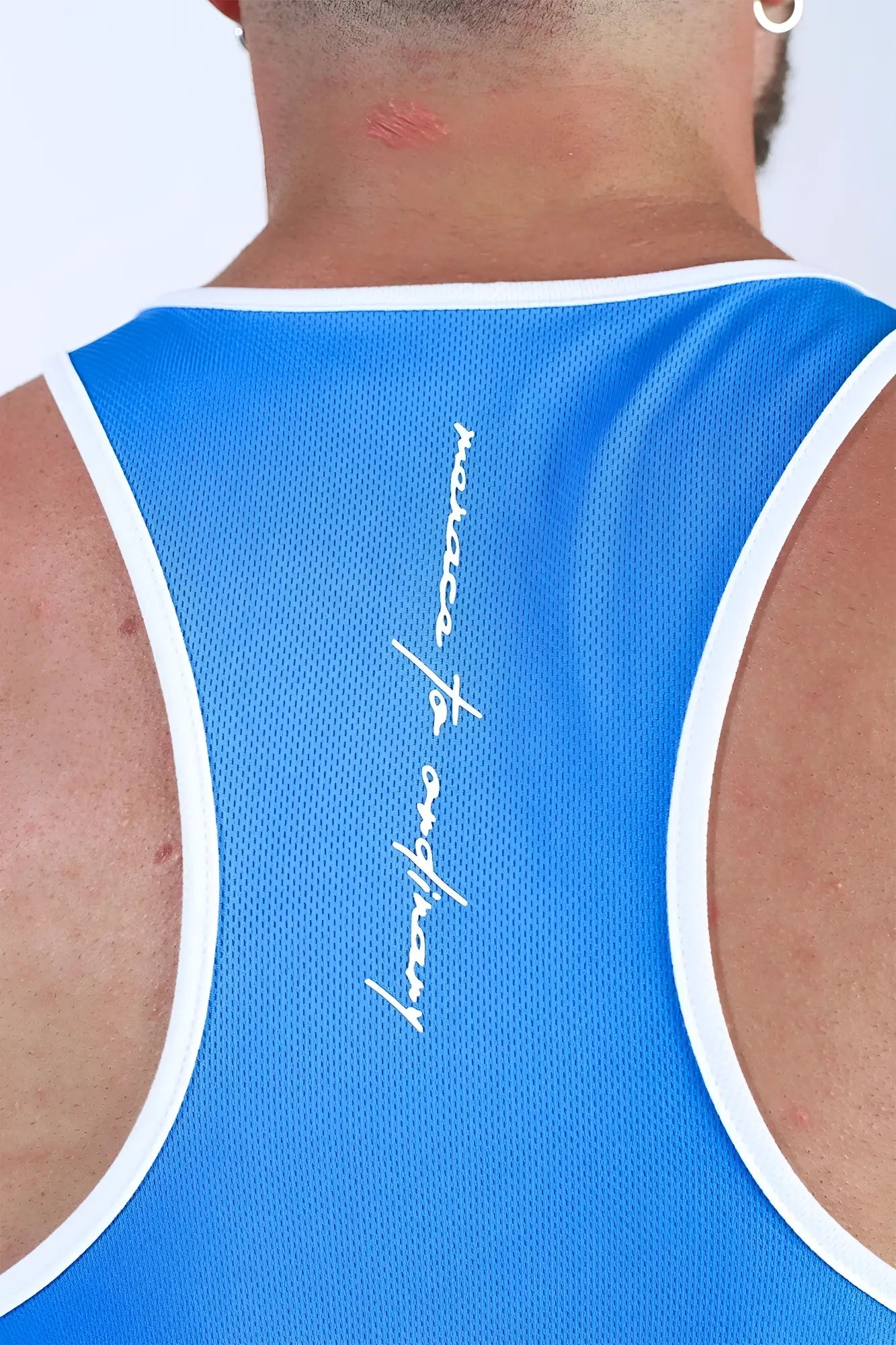 Back view of jed north fast-dry bodybuilding workout stringer tank top in blue mesh with white trim and cursive logo
