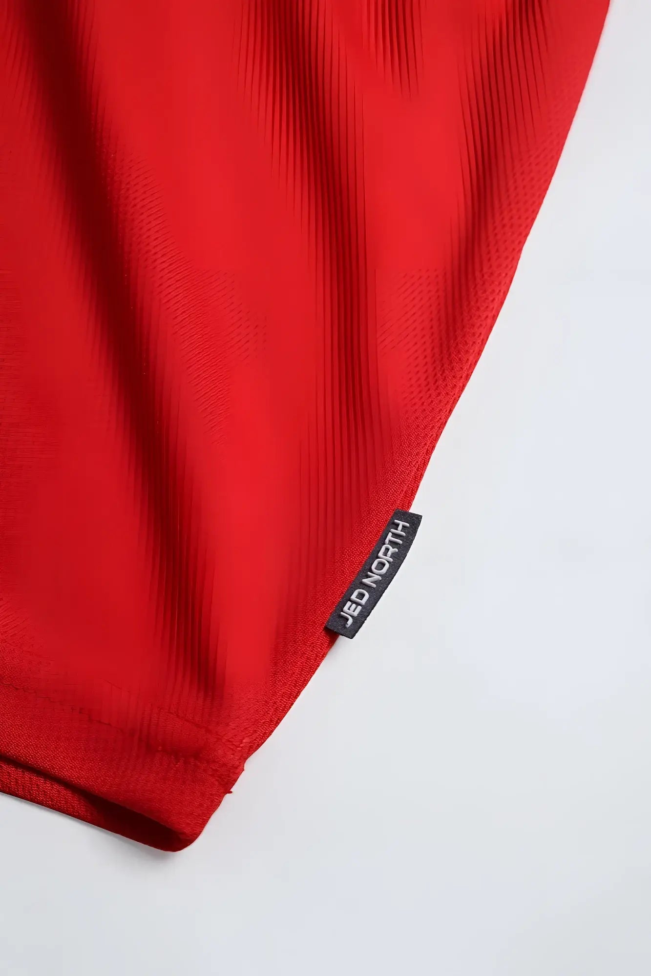 Fast dry bodybuilding workout stringer in oh canada red mesh fabric with black jed north brand tag visible