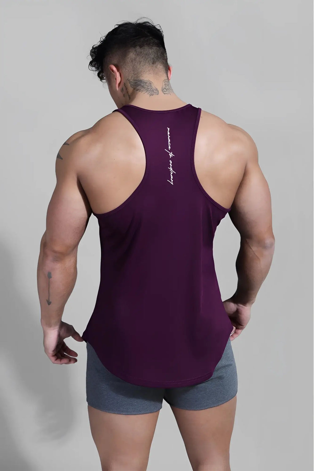 Back view of jed north fast dry bodybuilding workout stringer in dark purple sleeveless racerback with white script branding