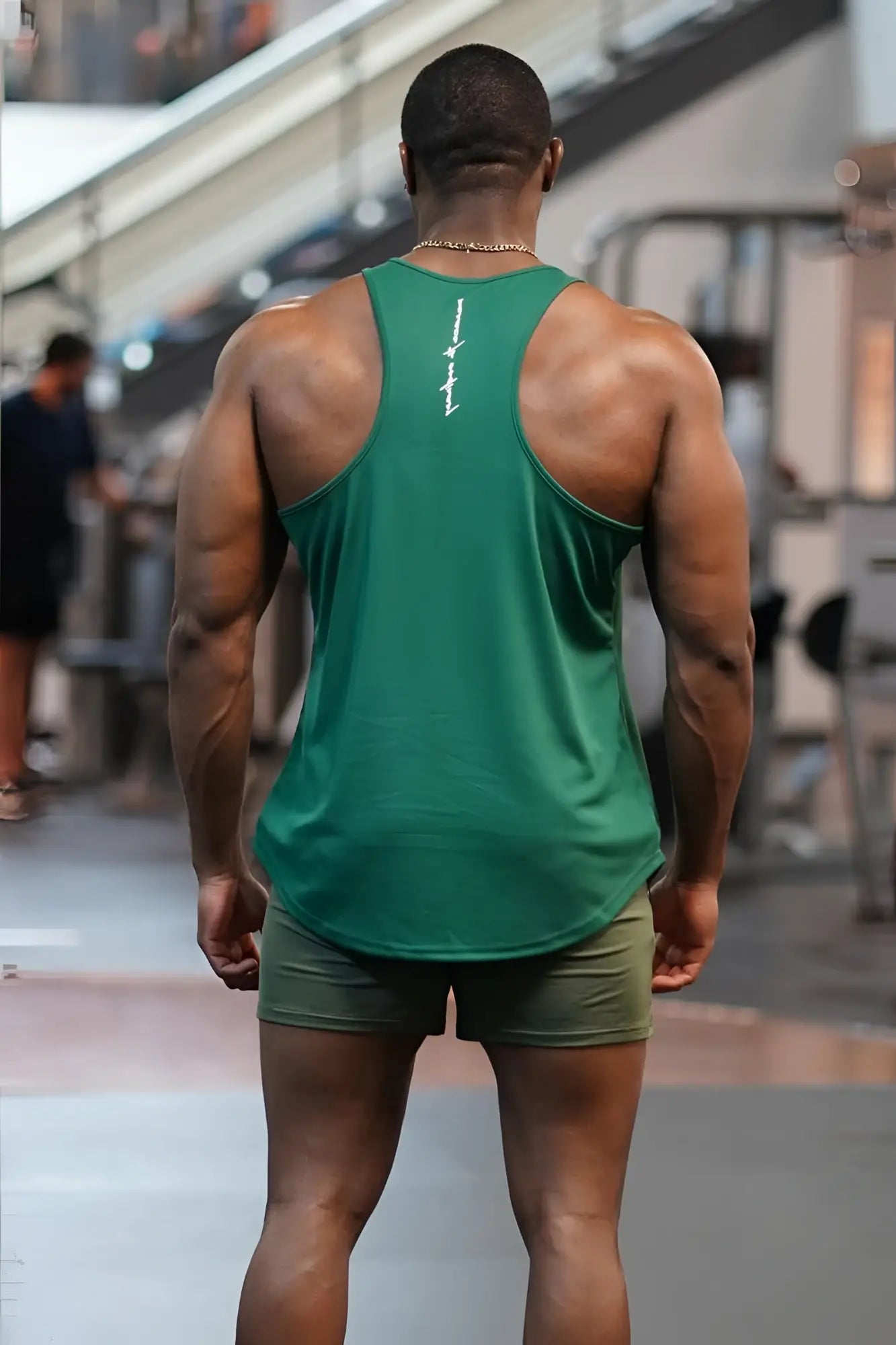 Back view of a green emerald jed north fast-dry bodybuilding workout stringer tank top with a white vertical logo