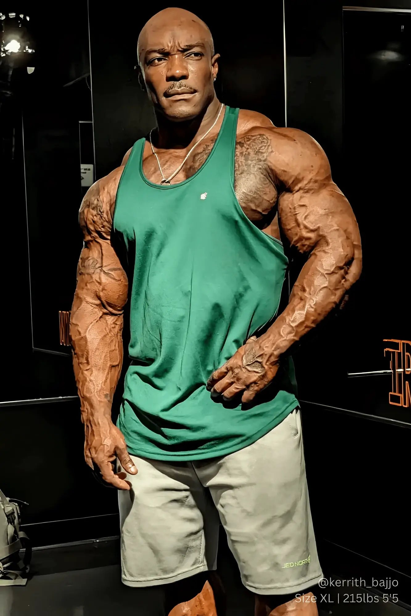 A muscular man wearing a green jed north fast-dry bodybuilding workout stringer with a small white chest logo