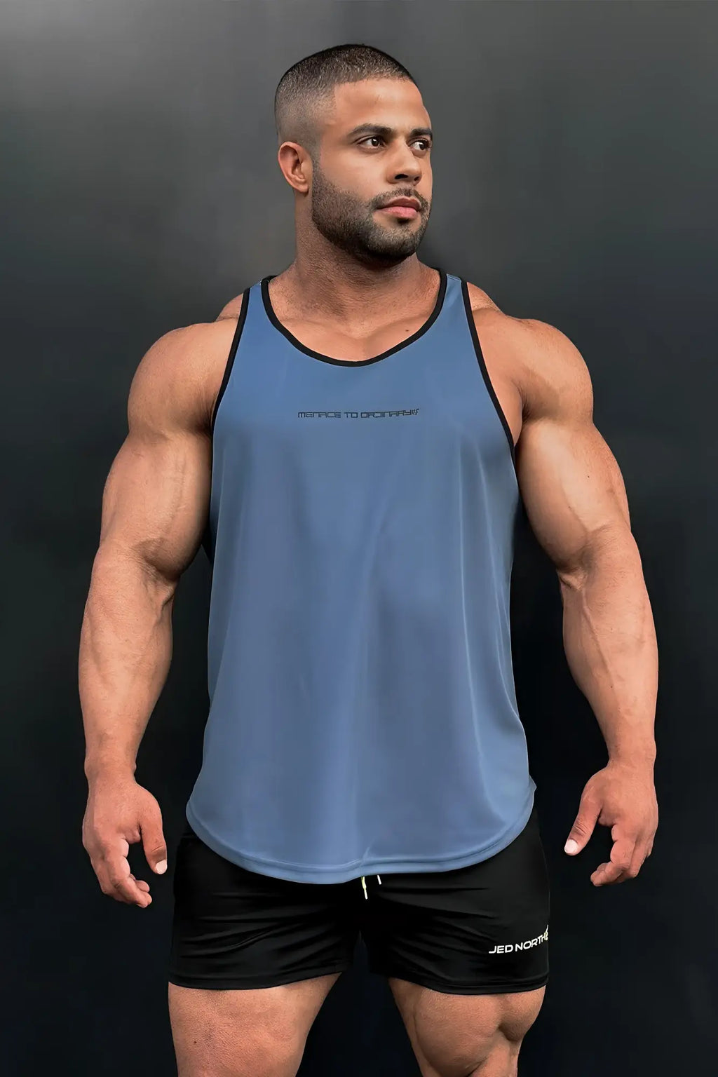Blue athletic tank top with black trim and subtle rebel to born text designed for bodybuilding workouts
