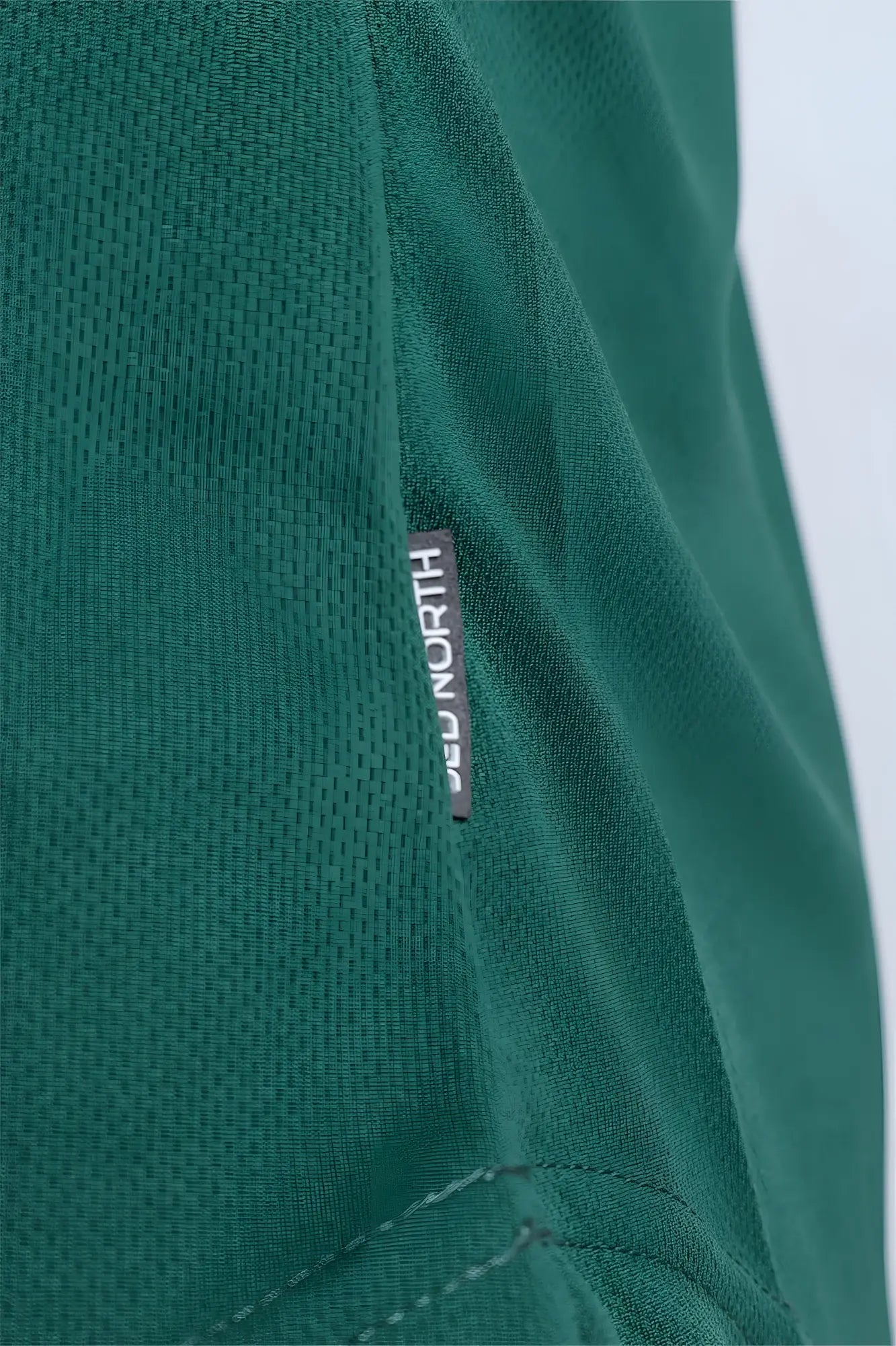 Dark green textured fast-dry bodybuilding workout stringer with a small black deu north brand tag and neon logo