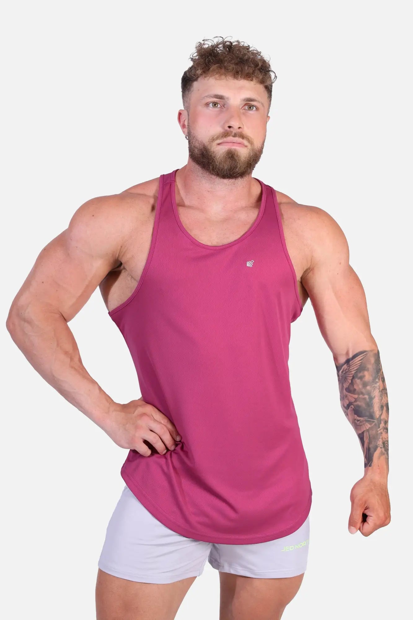 A magenta fast-dry bodybuilding workout stringer tank top with a scoop neckline and subtle brand logo on the chest