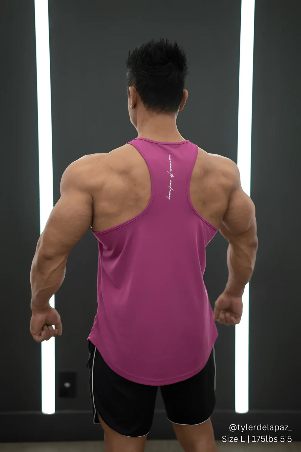 A vibrant magenta fast dry bodybuilding workout stringer tank top with racerback design and white script branding on back