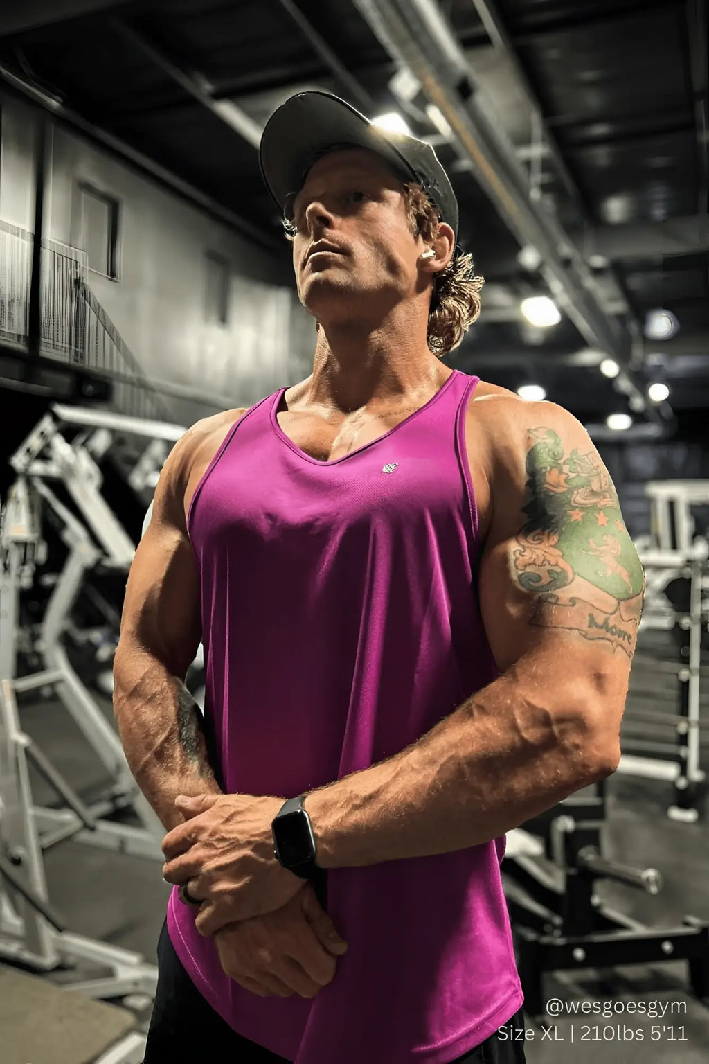 A vibrant magenta fast dry bodybuilding workout stringer tank top with classic v neck and subtle brand logo on chest