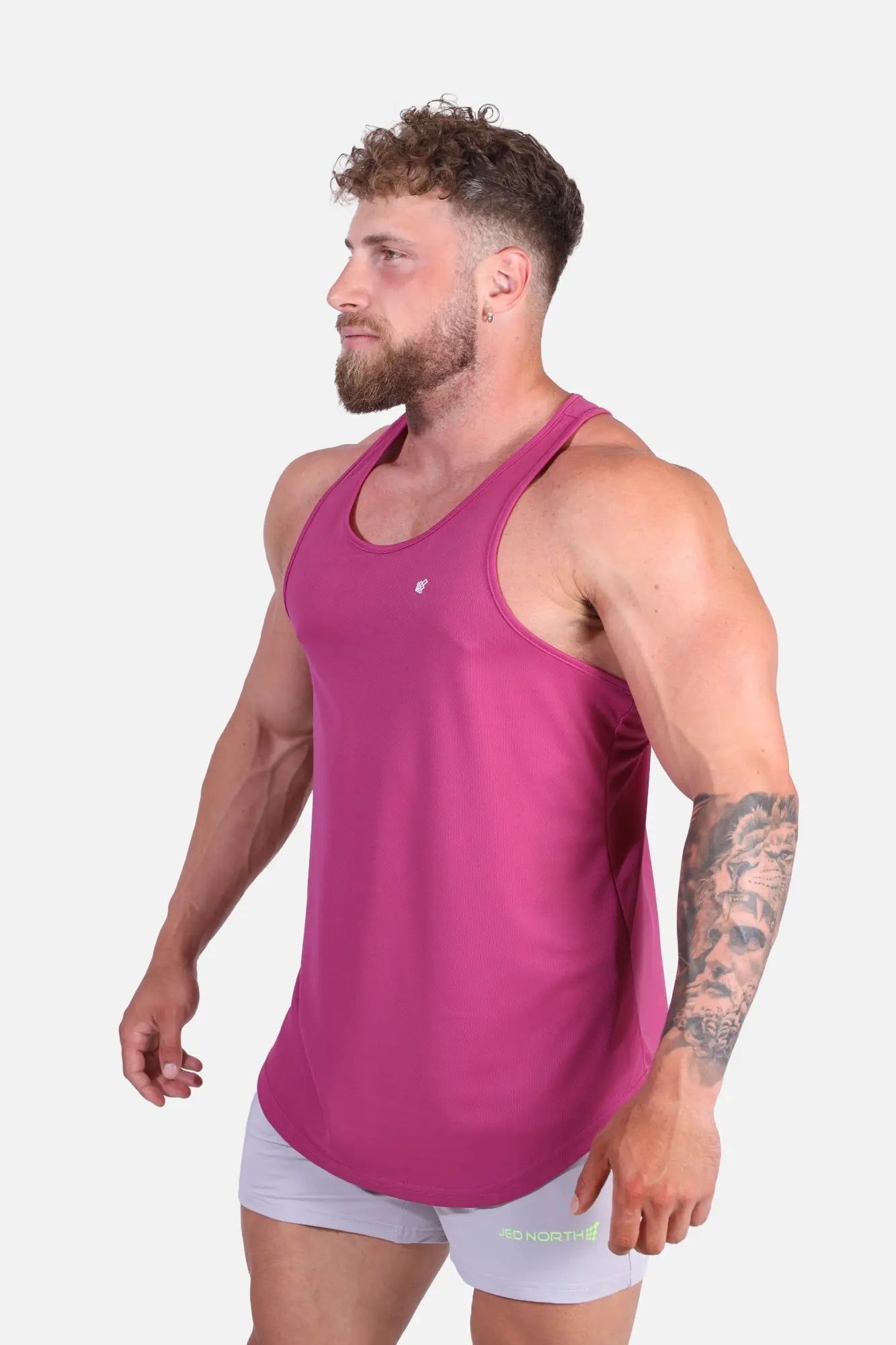 A vibrant magenta fast-dry sleeveless bodybuilding workout stringer with a fitted design and small chest logo