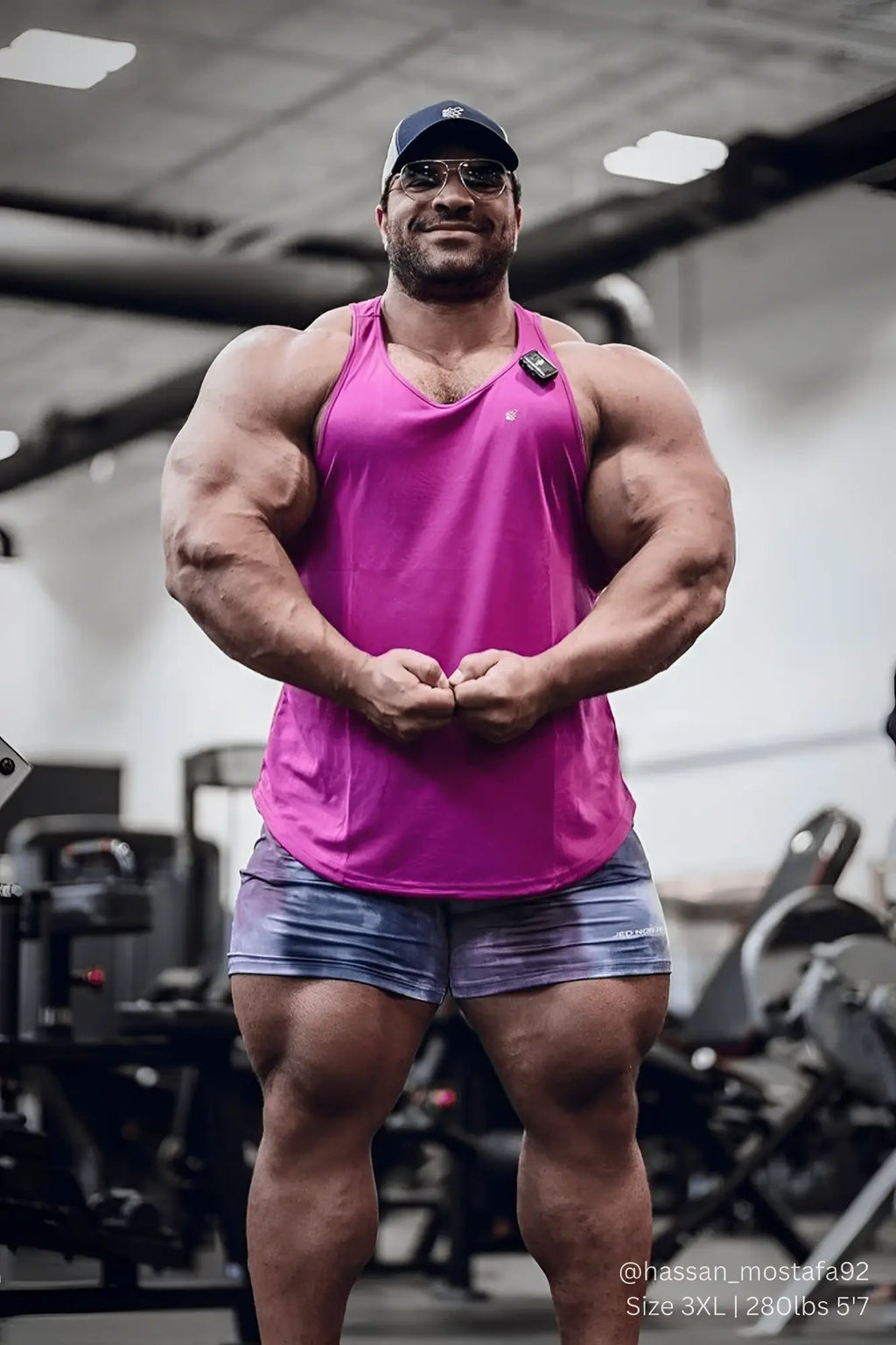 A vibrant magenta fast-dry sleeveless bodybuilding workout stringer with a small black logo on the upper left chest