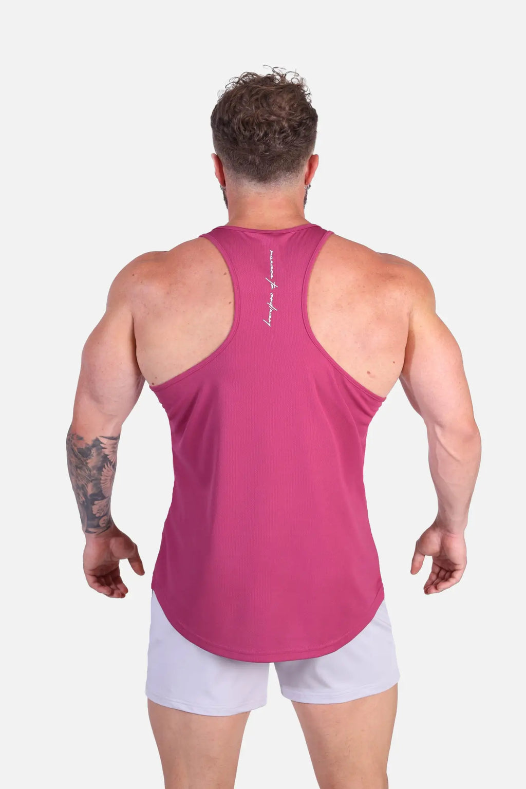 Back view of a vibrant magenta fast dry bodybuilding workout stringer tank top with racerback and white script branding