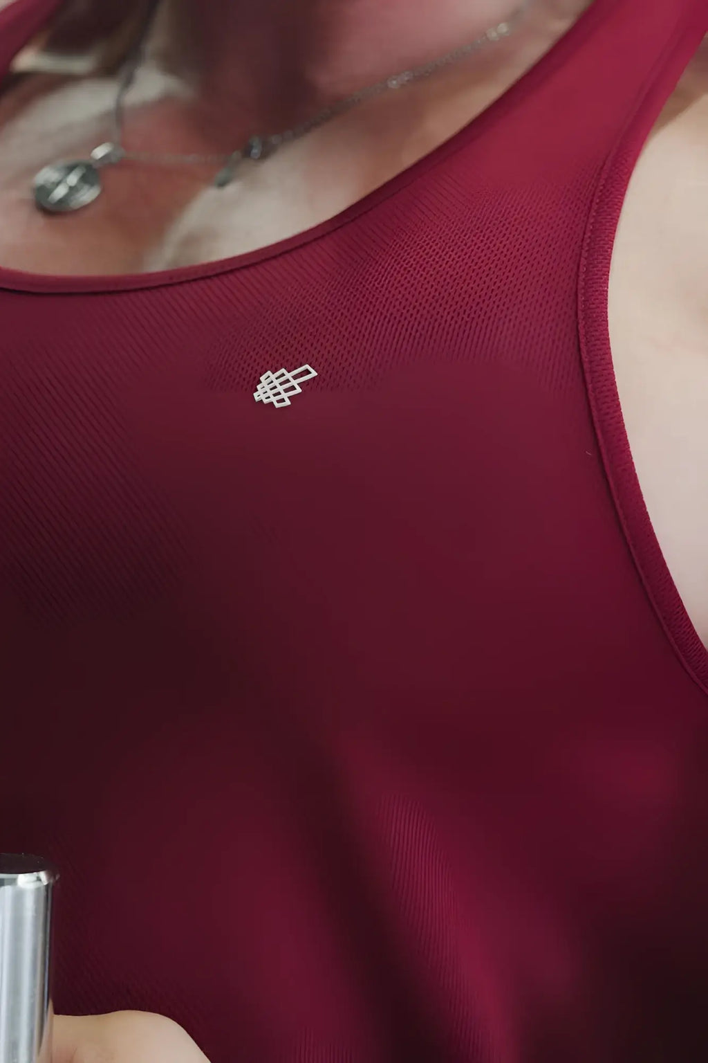 A small silver geometric logo embroidered on a deep red jed north fast dry bodybuilding workout stringer tank top