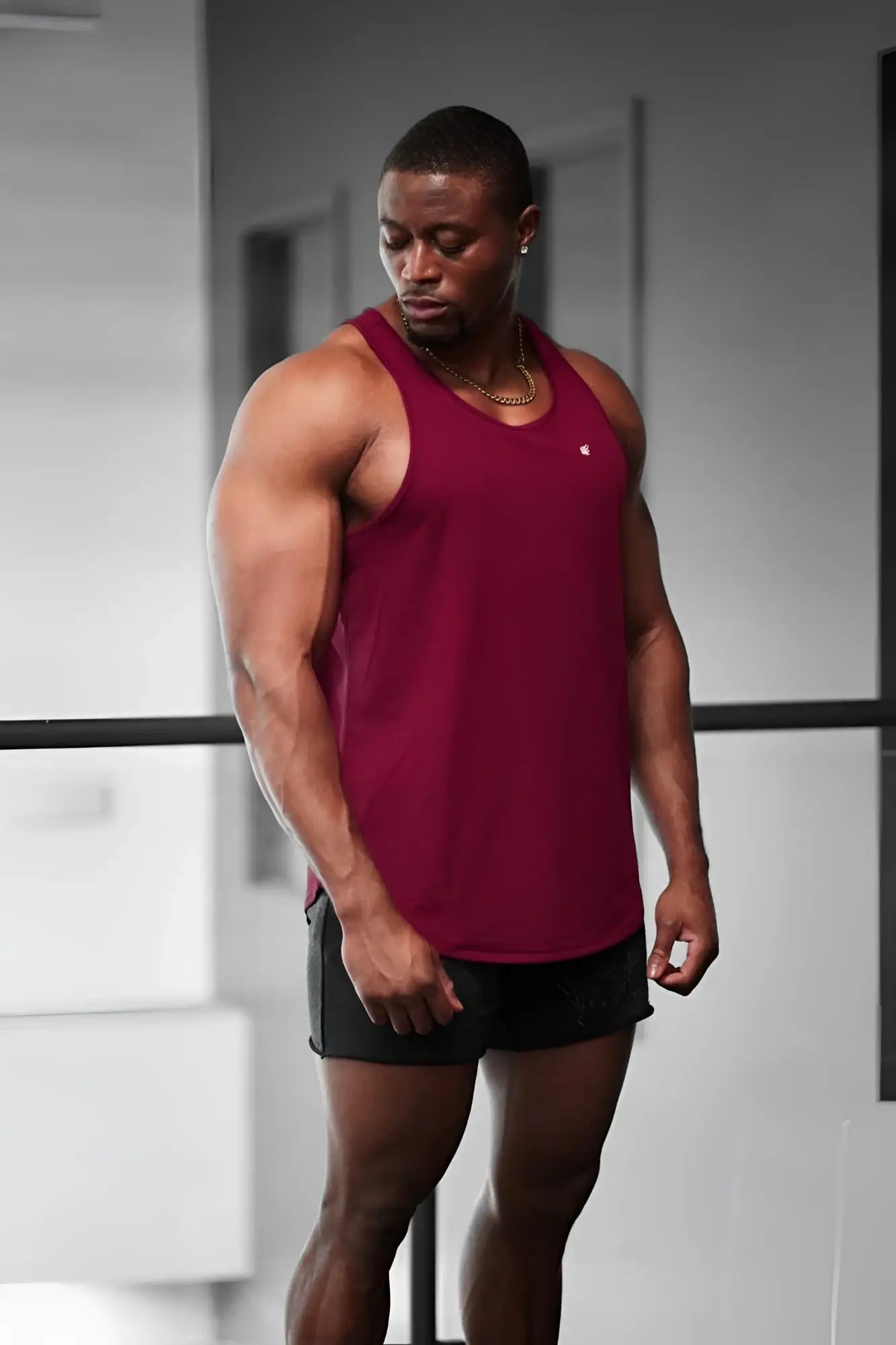 Maroon sleeveless Jed North fast-dry bodybuilding workout stringer tank top with small white logo on left chest