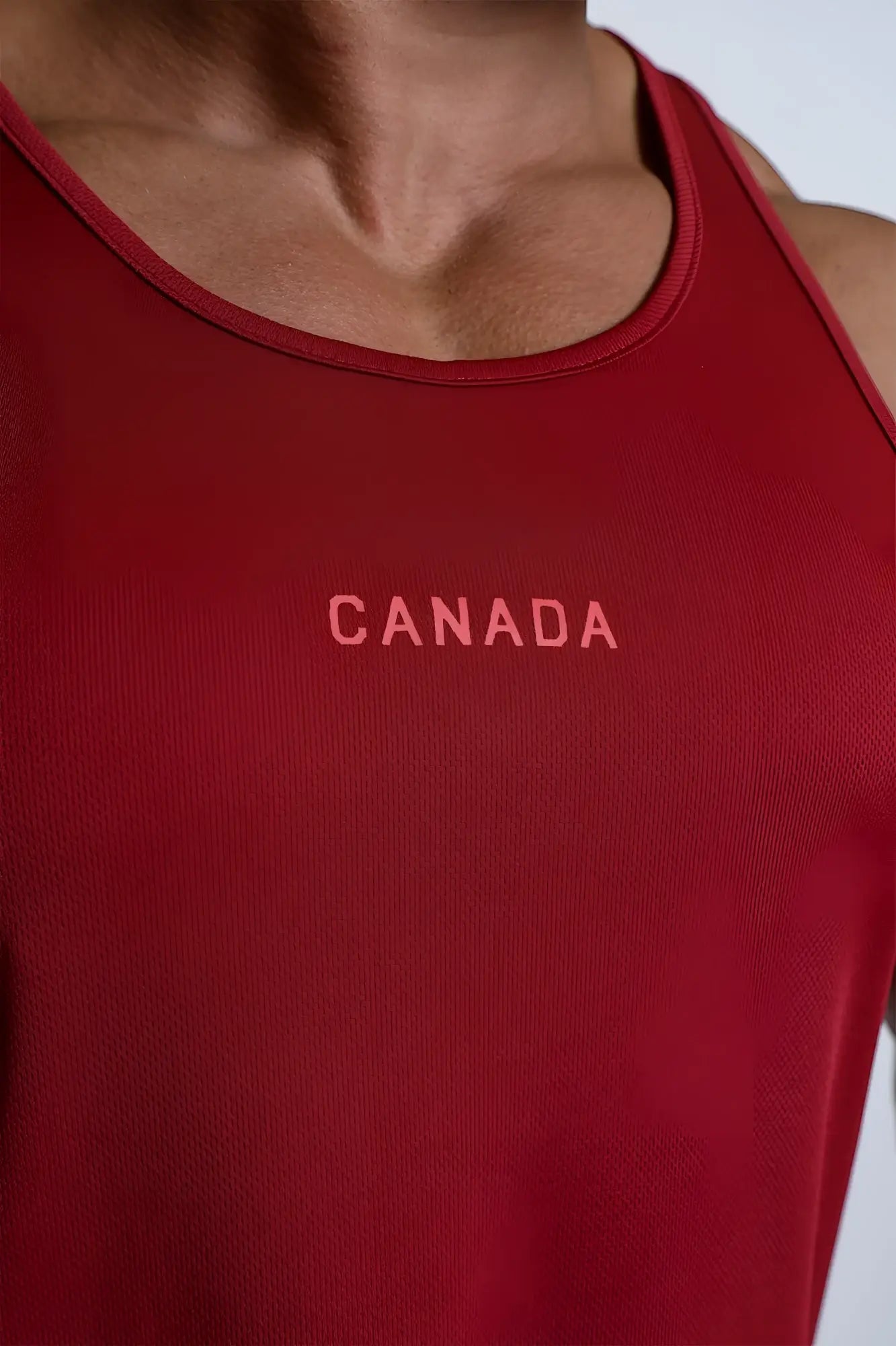 Fast-dry maroon bodybuilding workout stringer tank top with canada logo embroidered in pinkish hue on chest