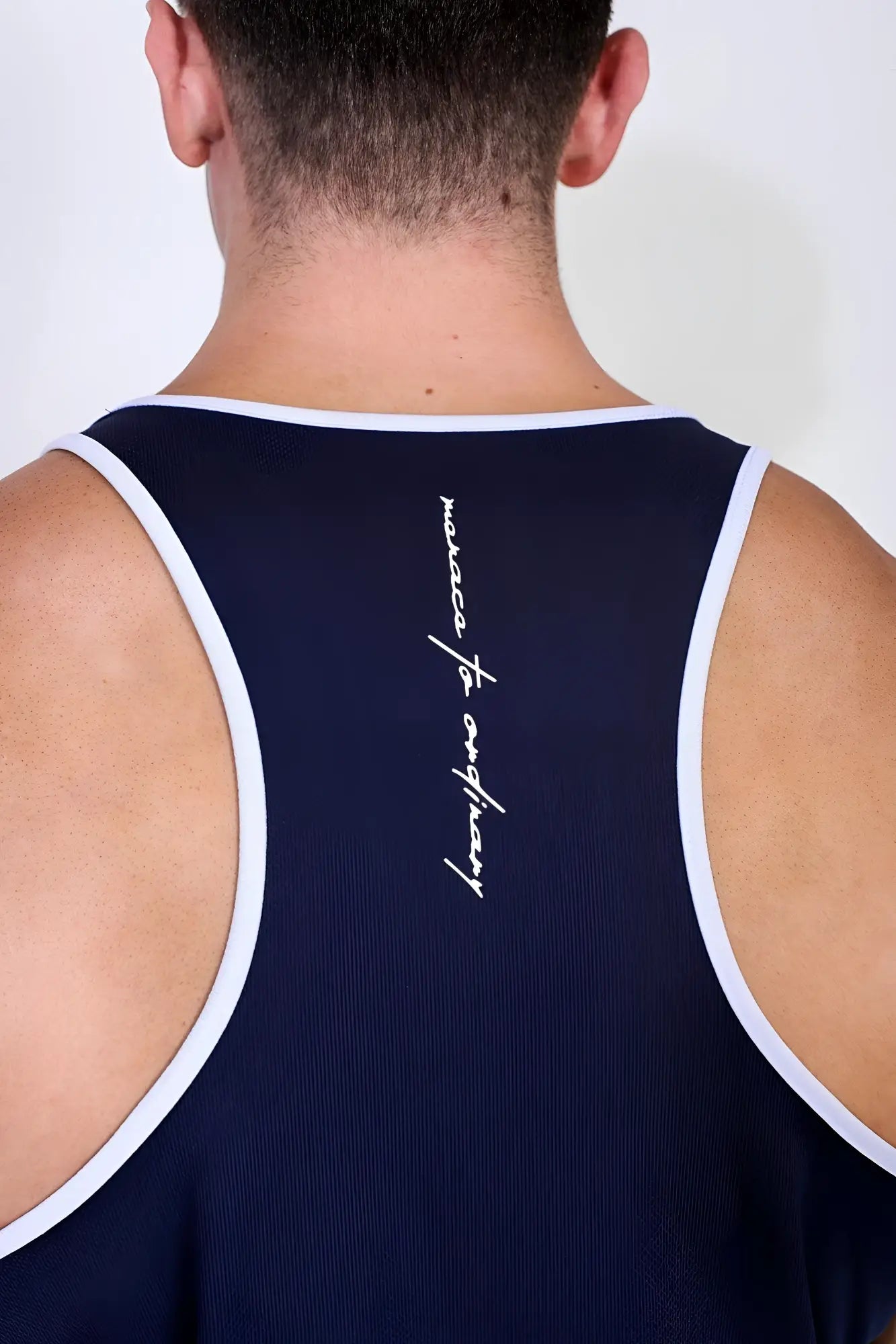 Back view of navy blue fast-dry bodybuilding workout stringer tank top with white trim and marseille for everybody logo