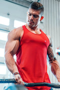 A man wearing a vibrant red fast-dry bodybuilding workout stringer tank top with a small logo on the chest