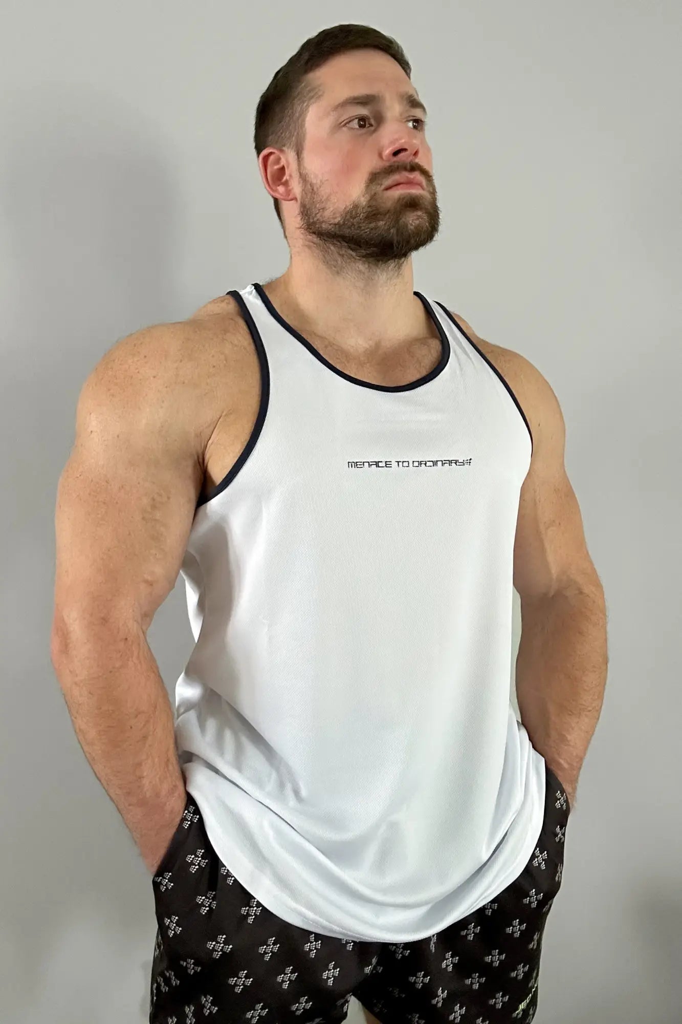 White fast-dry bodybuilding workout stringer tank top with black trim and subtle menace to crops text on chest