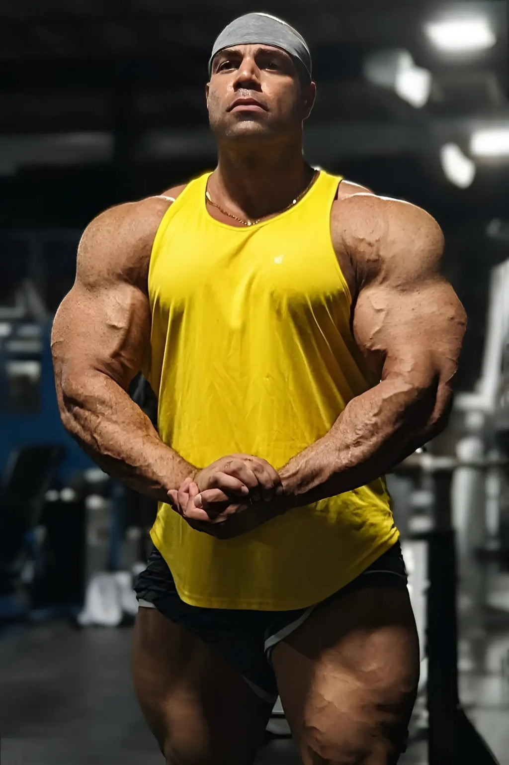 Jed North fast-dry bodybuilding workout stringer in bright yellow sleeveless tank top worn by a muscular individual