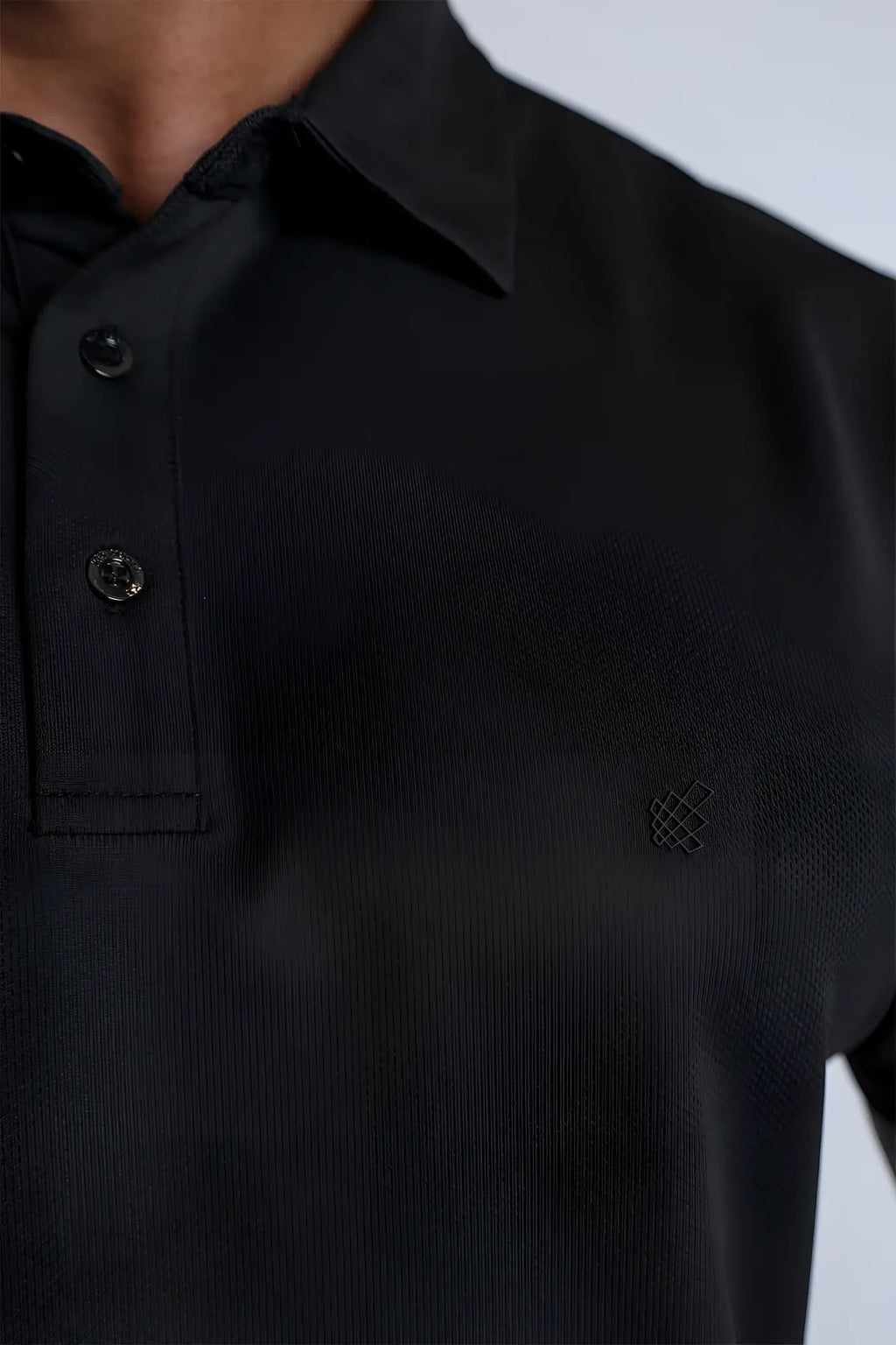 Black fast-dry polo t-shirt with textured fabric and subtle embroidered logo on the chest