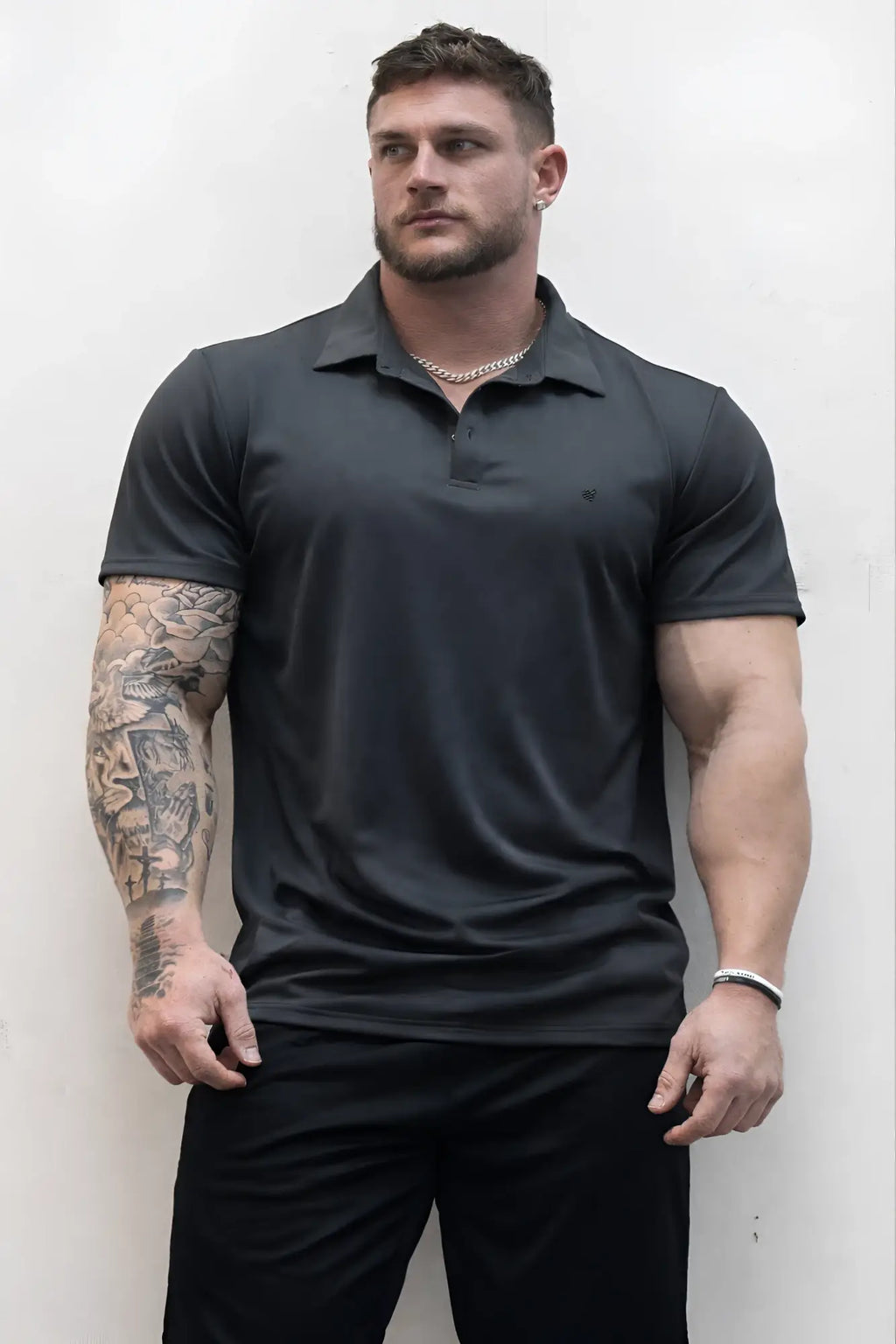 Black short-sleeved fast-dry polo t-shirt with subtle chest logo in dark gray for active wear