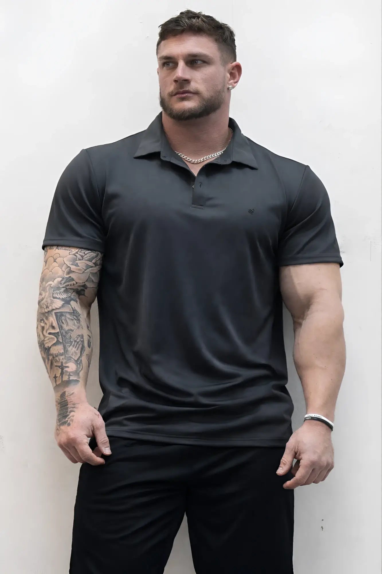 Black short-sleeved fast-dry polo t-shirt with subtle chest logo in dark gray for active wear