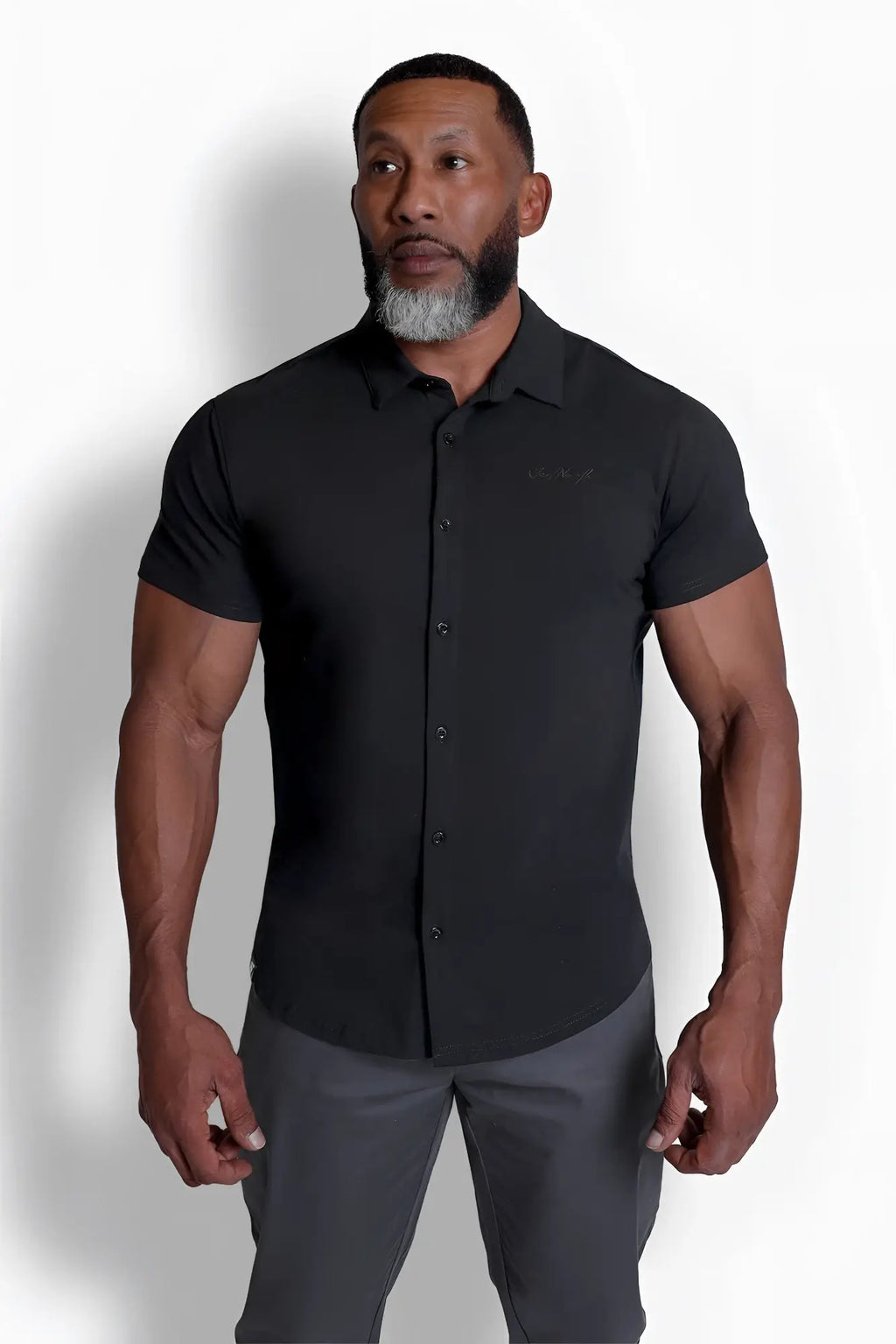 Black short-sleeved flex premium stretch button-up shirt in onyx black with subtle embroidered logo on chest