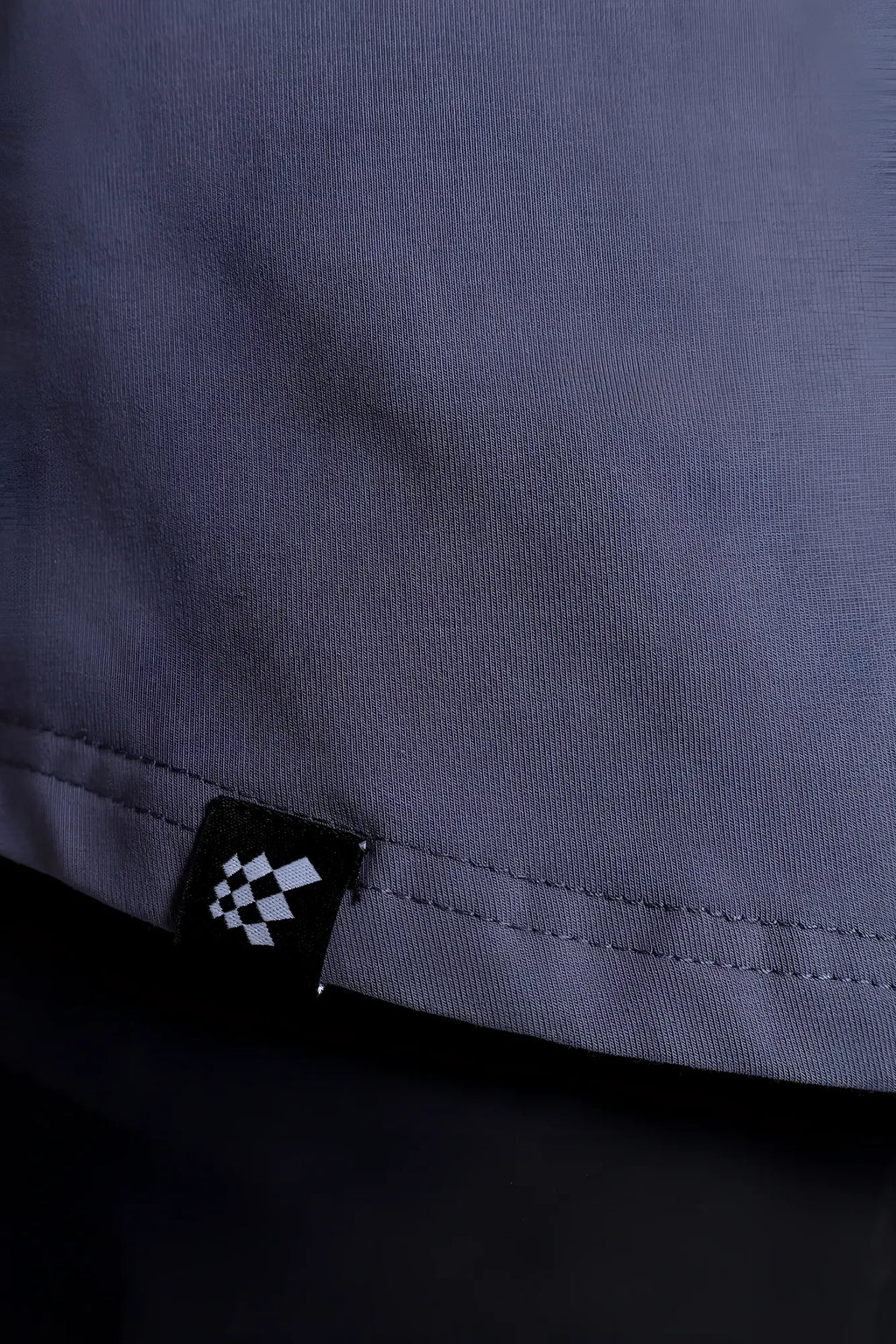 Flex premium stretch button-up shirt storm gray showing dark gray woven fabric and black tag with white checkered pattern