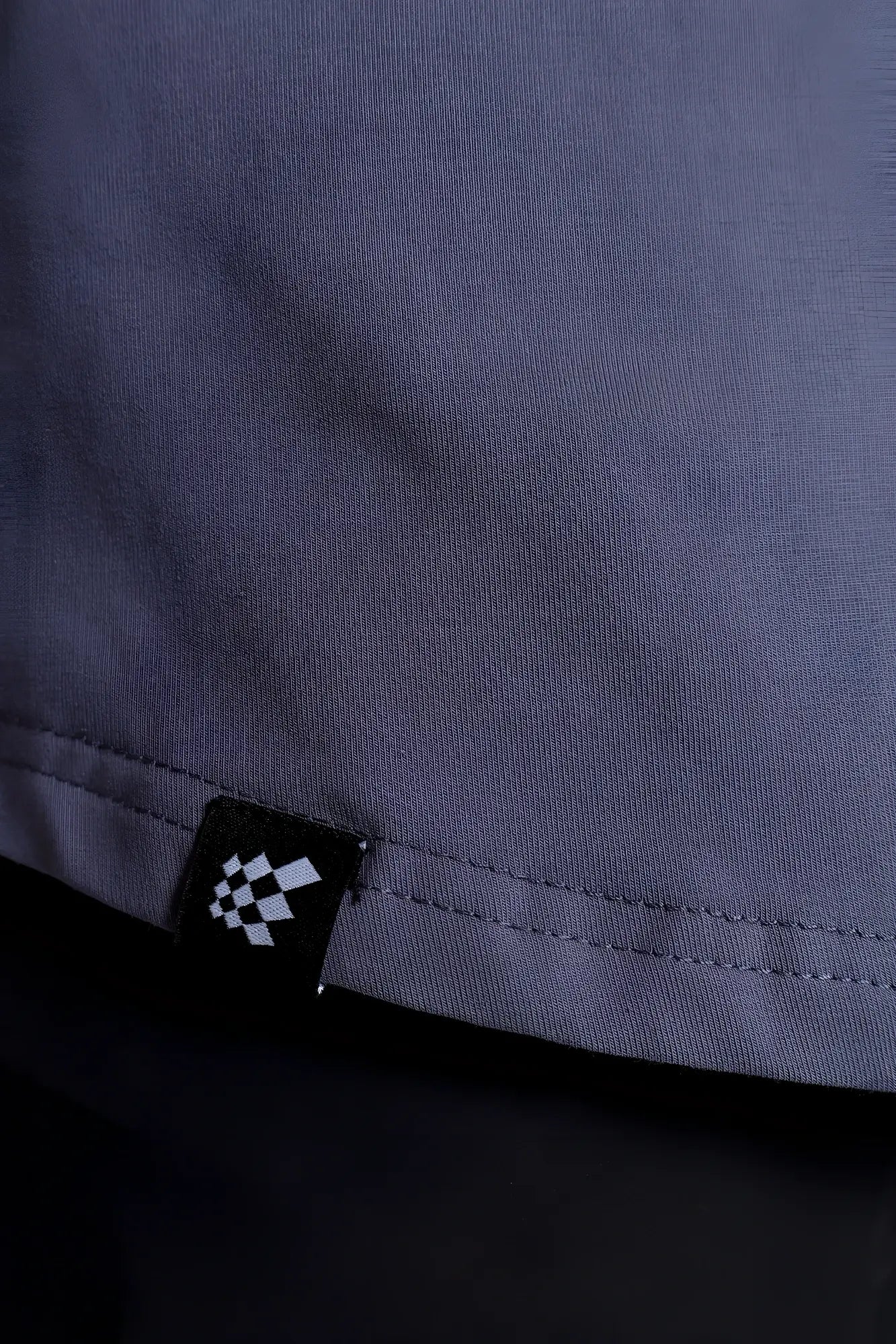 Flex premium stretch button-up shirt storm gray showing dark gray woven fabric and black tag with white checkered pattern