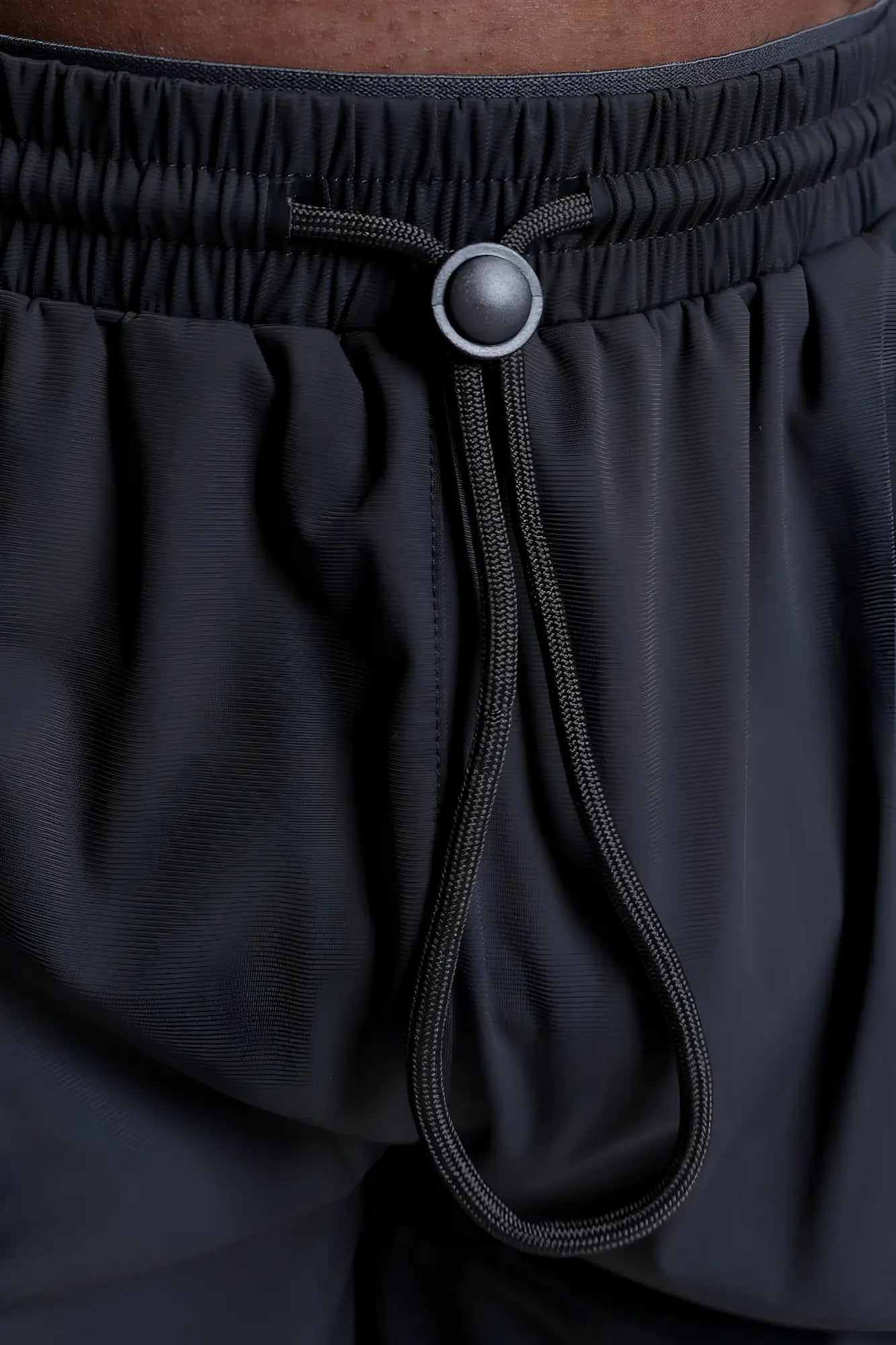 Fortis men’s athletic shorts in black with a drawstring waistband and silver-toned button for adjustable fit