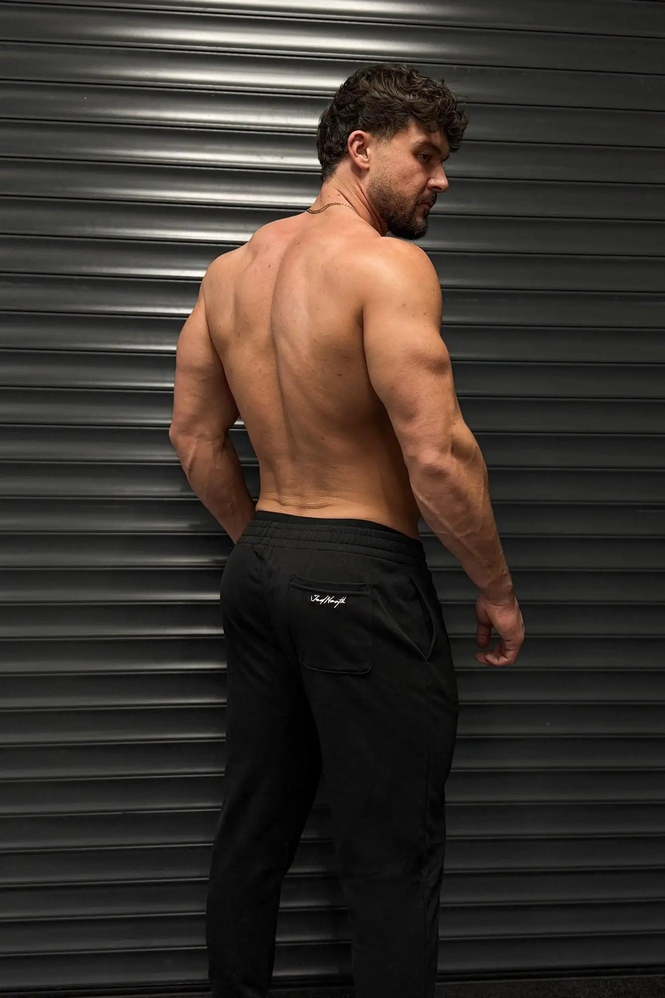 Back side view of black Jed North French Terry athletic training joggers with subtle white logo on back pocket