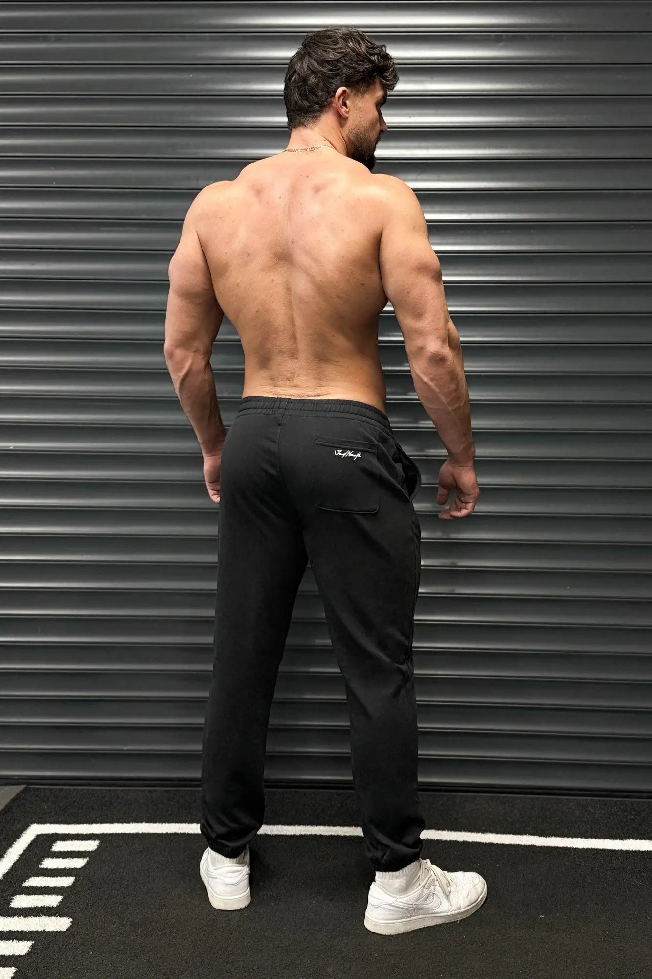 Back view of jed north french terry black athletic training joggers with a subtle white logo on the pocket