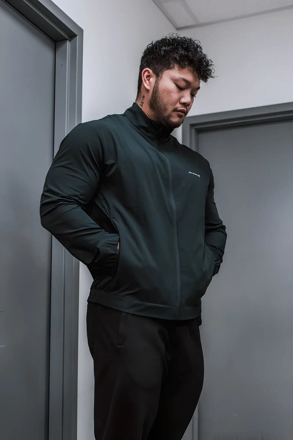 Full-zip training jacket in dark green with a subtle brand logo on the left chest for athletic wear