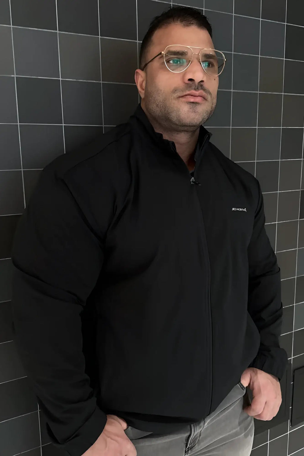 Full-zip training jacket black with subtle embroidered logo on left chest designed for athletic wear