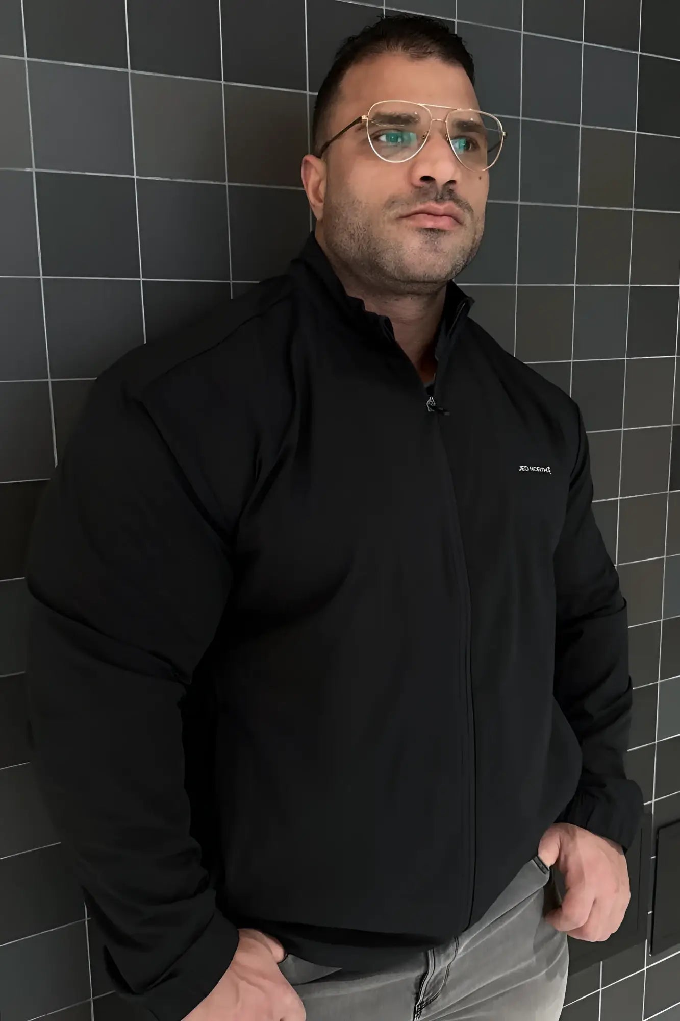 Full-zip training jacket black with subtle embroidered logo on left chest designed for athletic wear
