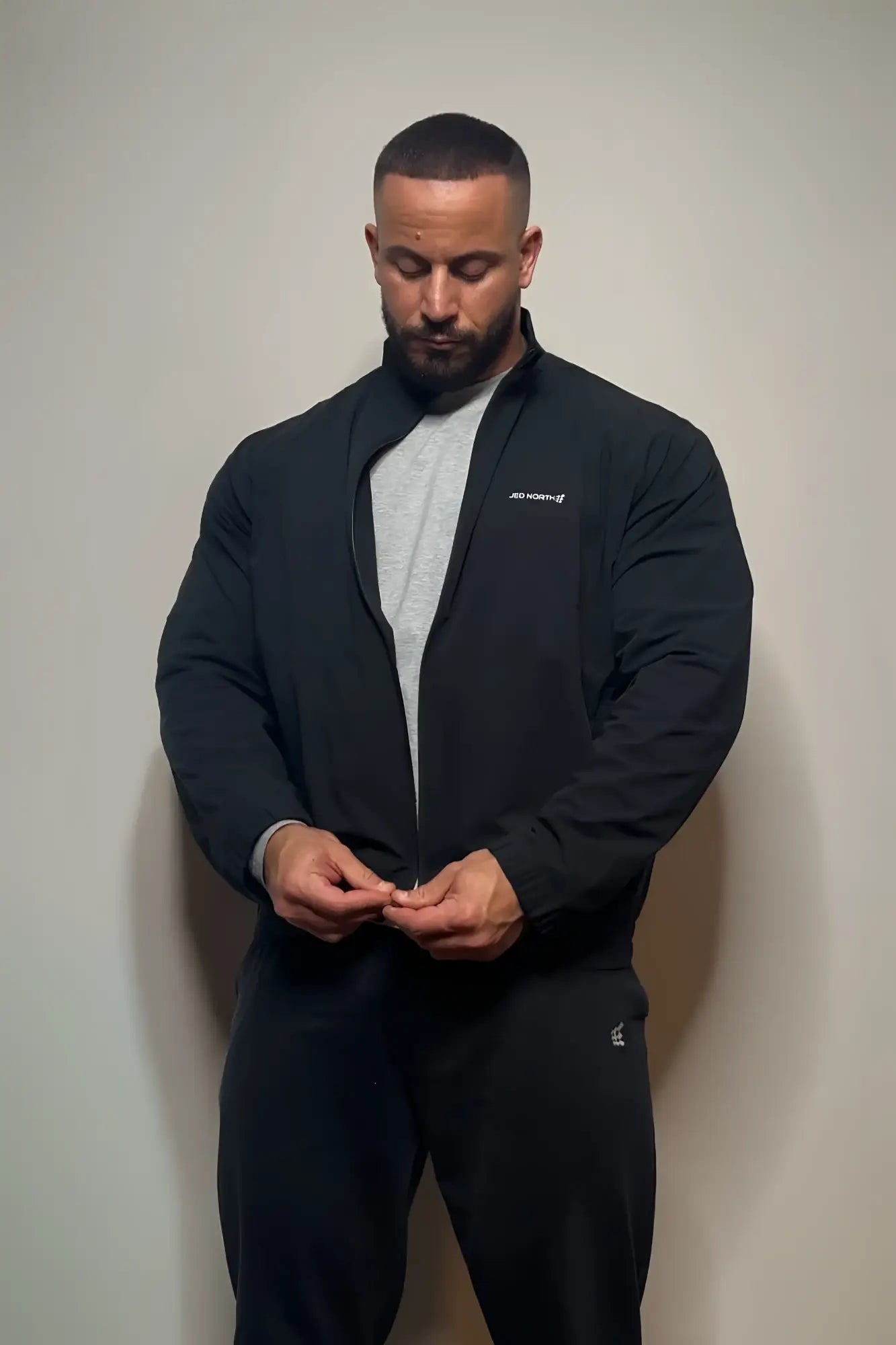 Full-zip training jacket black with a subtle white logo on the left chest perfect for workouts and casual wear