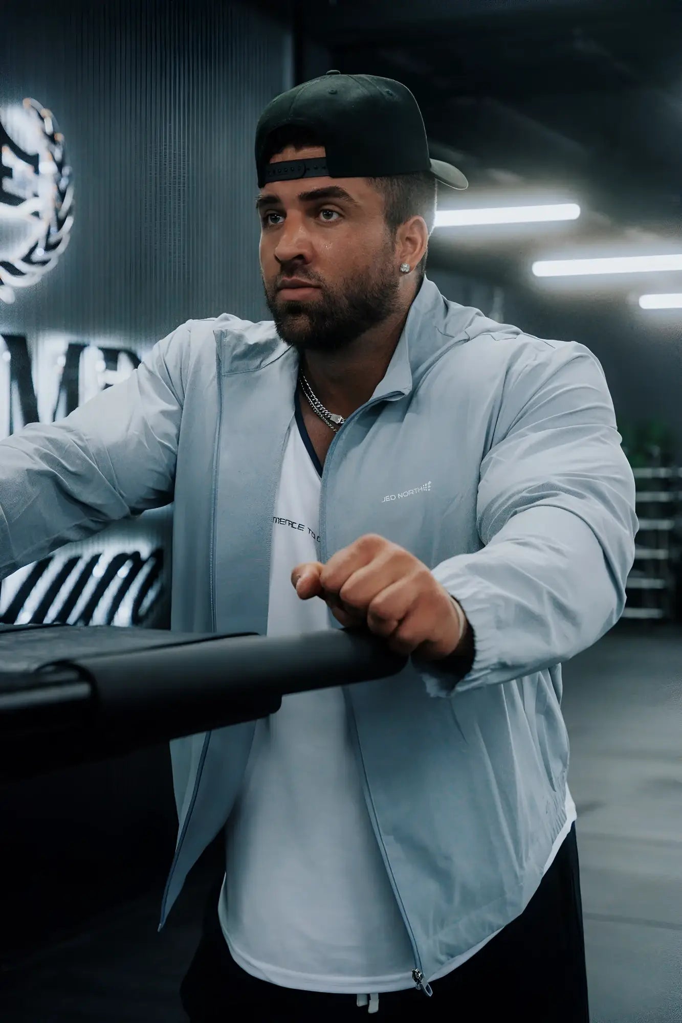 Light blue full-zip training jacket with subtle chest branding designed for versatile athletic wear