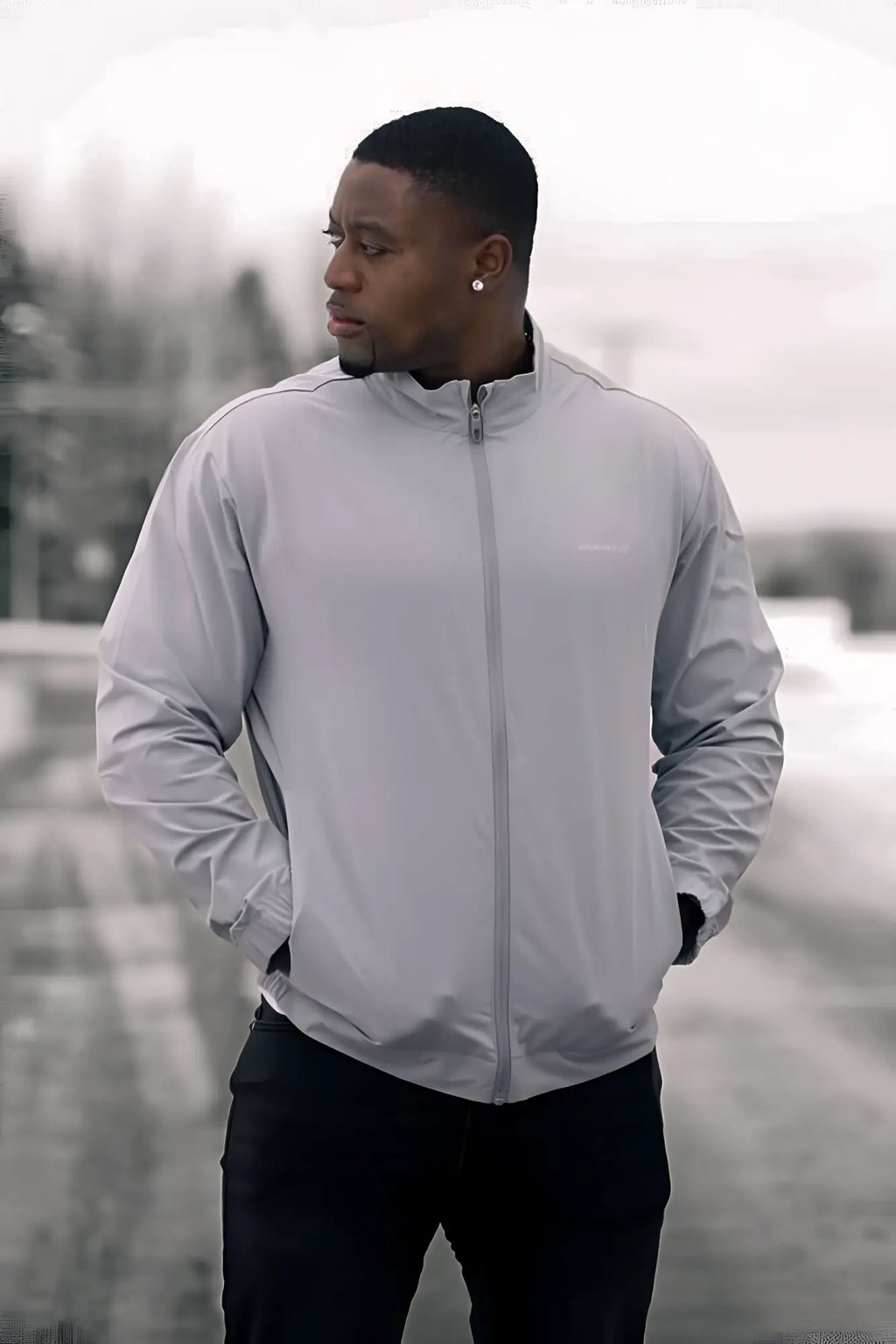 Light gray full-zip training jacket with subtle chest logo made of lightweight material for active wear